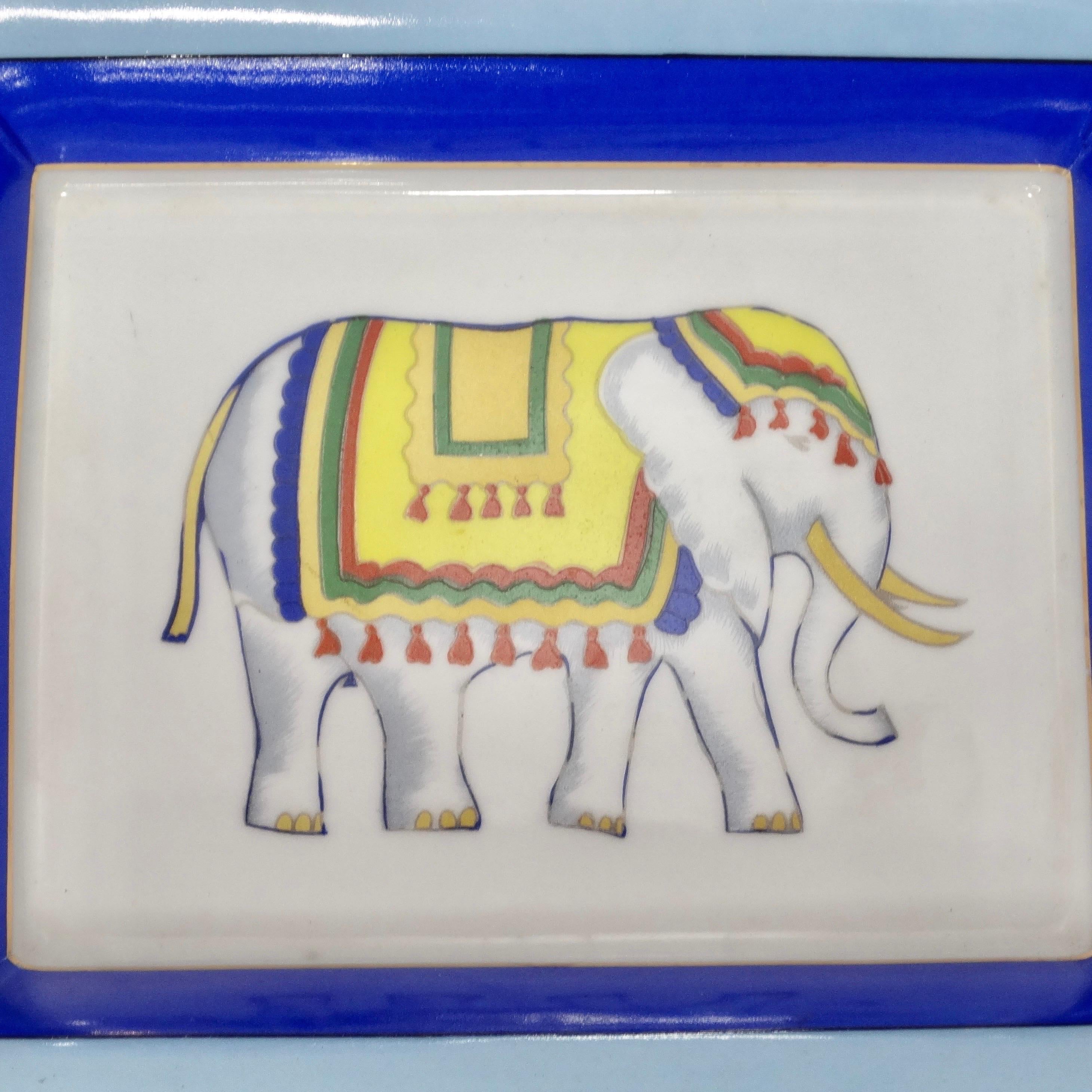 Do not miss out on this gorgeous 1980s porcelain glass ashtray! The perfect addition to your coffee table, this glass ashtray features a blue border with contrasting gold tone plating. The focal point of the ash tray is this beautiful yellow,