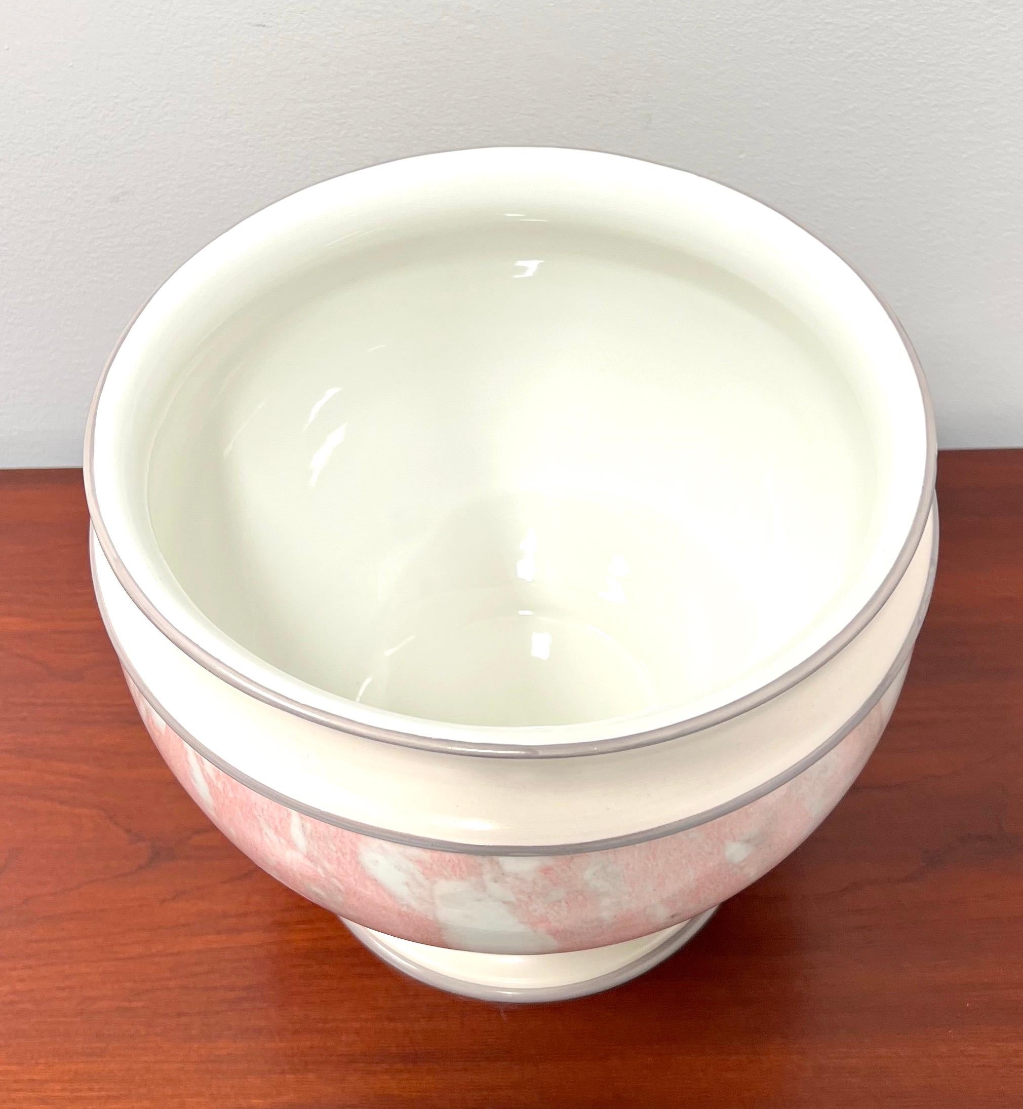 An Italian decorative porcelain centerpiece bowl, unbranded. A beautiful pink, white & gray color round porcelain bowl with a faux marble design, white color interior, and footed. Made in Italy, circa 1980's.

Measures:  10w 10d 9h, Weighs