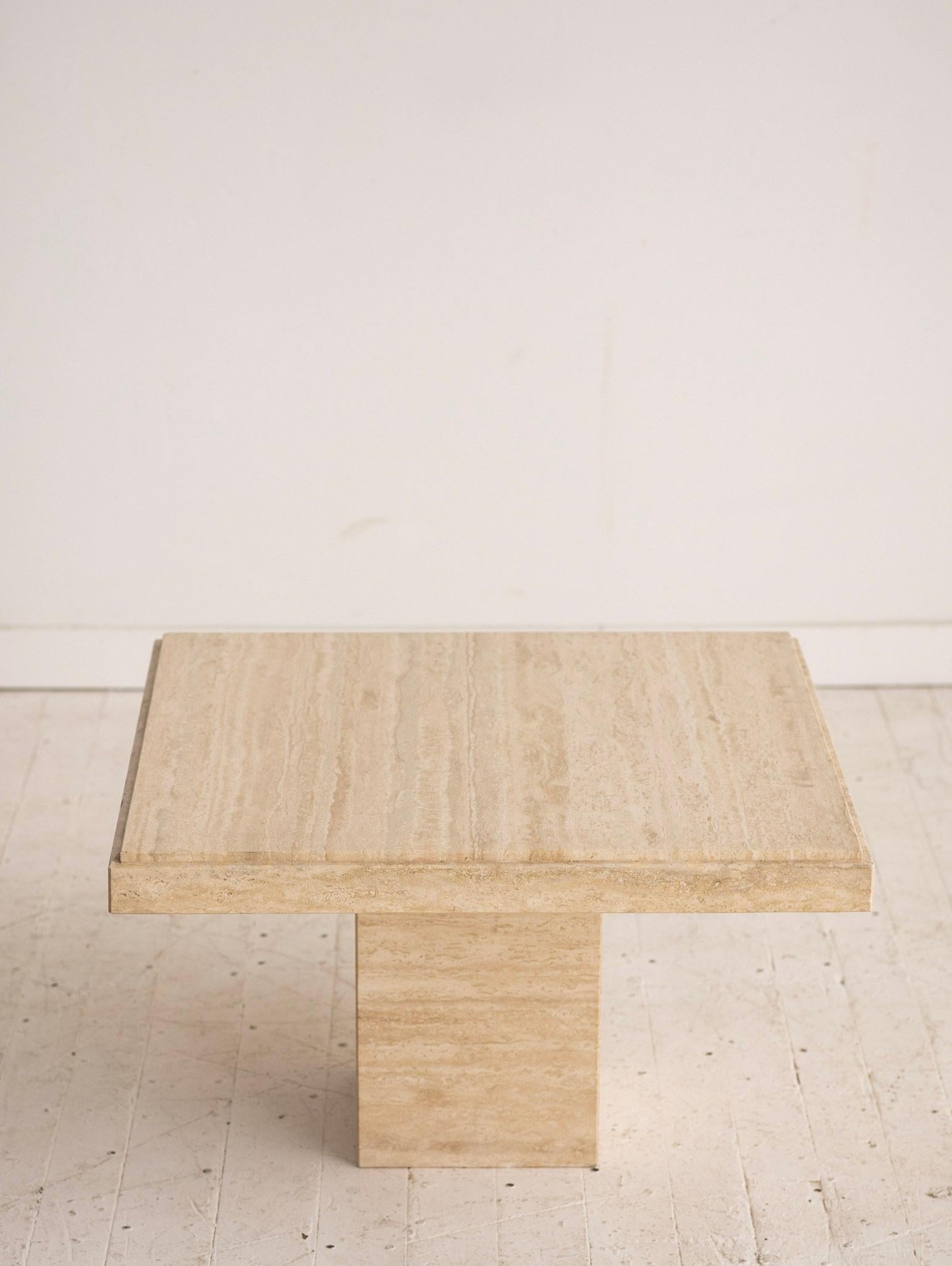 1980s square Italian travertine side table. Square travertine slab rests on hollow monolith base.