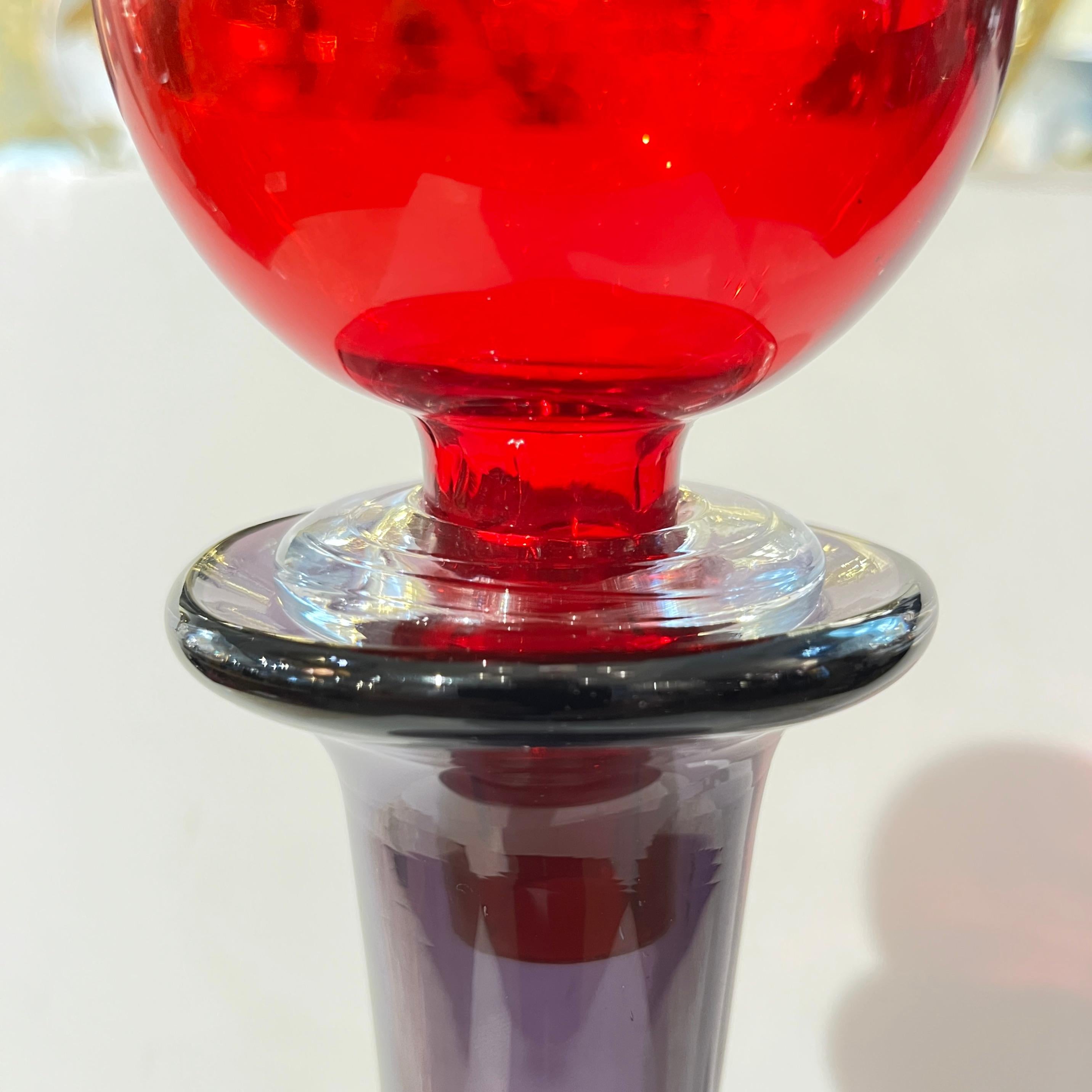 Questa bottiglia post-moderna in vetro soffiato di Murano mette in mostra la magistrale lavorazione colorata ispirata al Memphis Design e la forma fluida caratteristica dell'arte vetraria italiana di metà secolo. Il pezzo è soffiato a mano in un