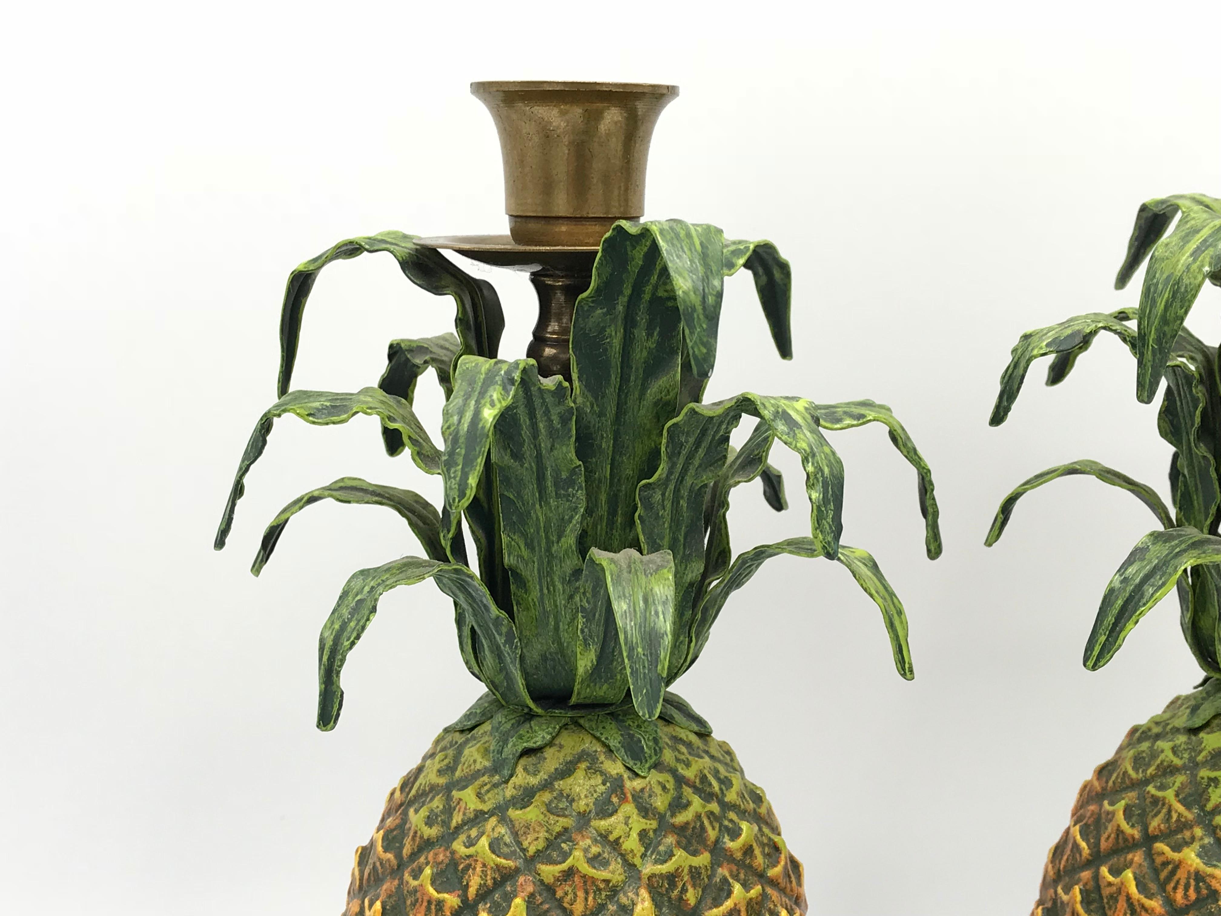 Offered is a stunning pair of 1980s Italian Tole pineapple sculptural candlesticks. Brass accents, mounting the pineapples to their dark-green marble bases. Heavy.