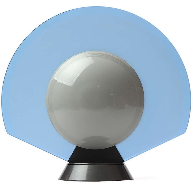 Une lampe de table spectaculaire et géométrique en verre bleu translucide avec des diffuseurs en plastique blanc fixés au sommet d'une base conique en acier lestée et pivotante. Vendu individuellement, paire disponible.