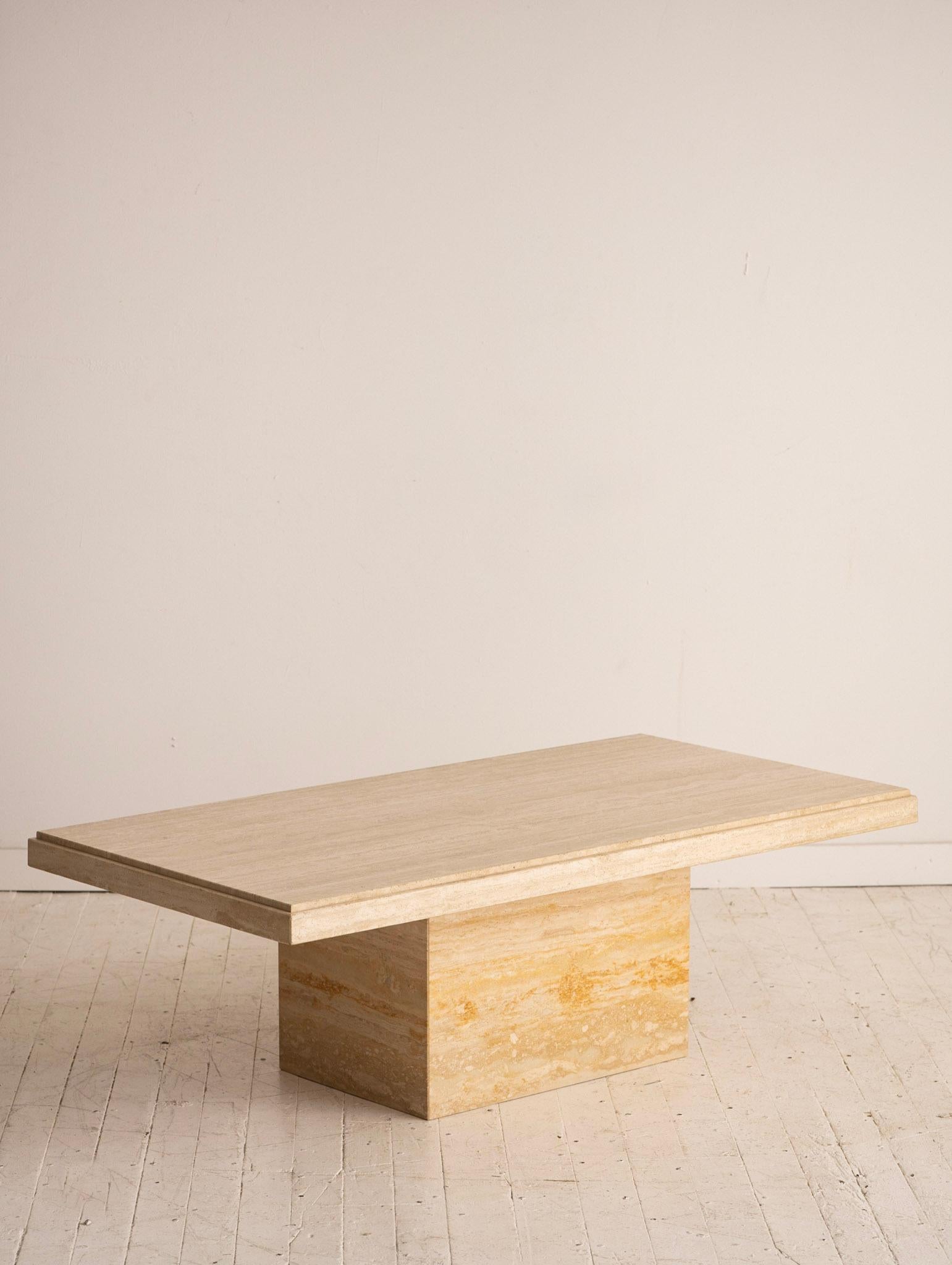 1980s Italian Travertine coffee table. Rectangular slab sits on top of a hollow travertine plinth base.