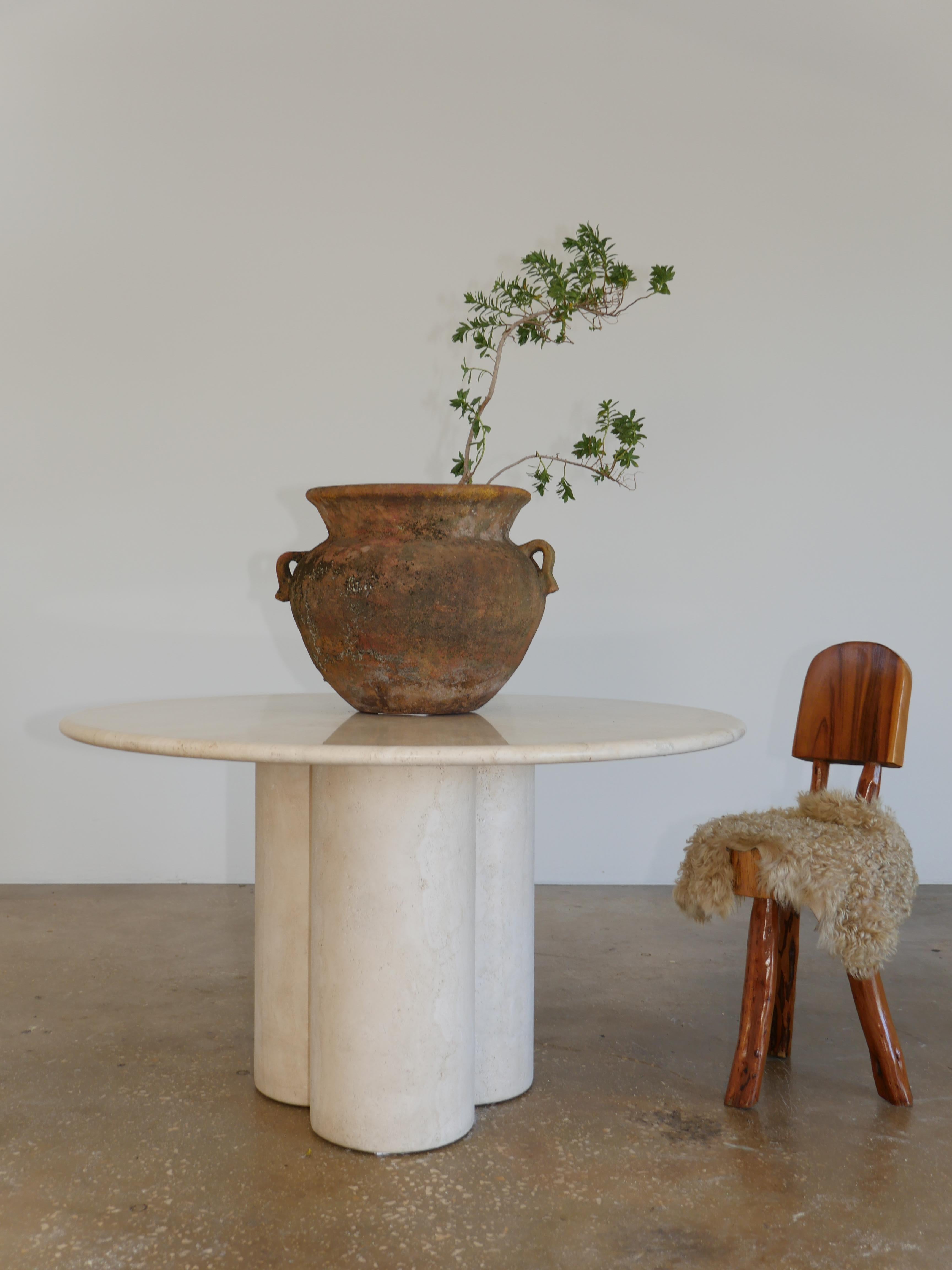 Exquisite vintage Italian, polished travertine marble dining table stamped 1988. The beautiful Navona, vein-cut travertine top, sits on on three solid thick travertine legs that interlock to make a unique clover shaped base.