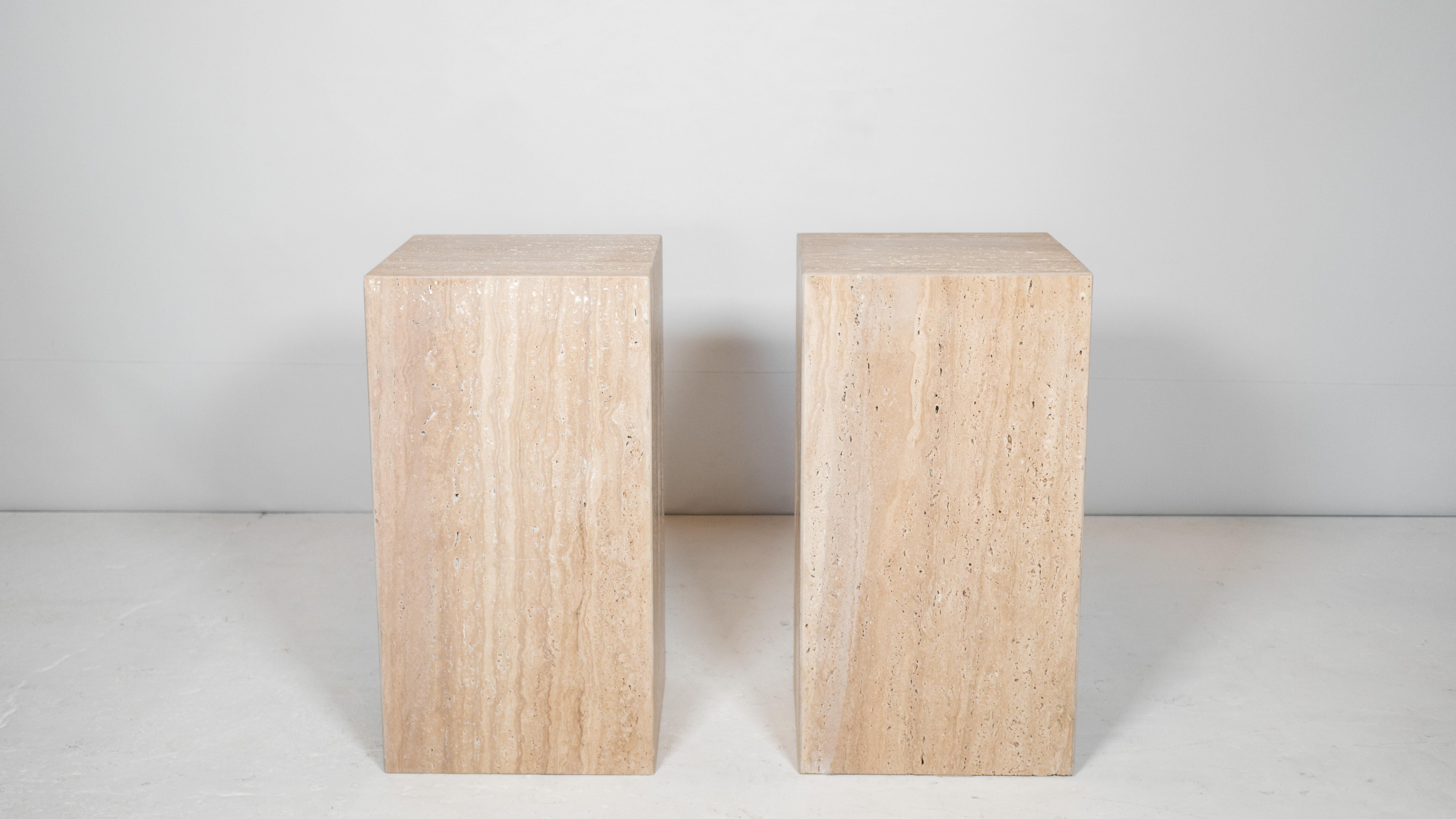 Impressive pair of large Italian travertine side tables, circa 1980s. Beautiful grain seen throughout the porous raw stone with vibrant neutral earth tones and hues. Presence offer elegance while maintaining minimalist design. Rectangle cuboid shape