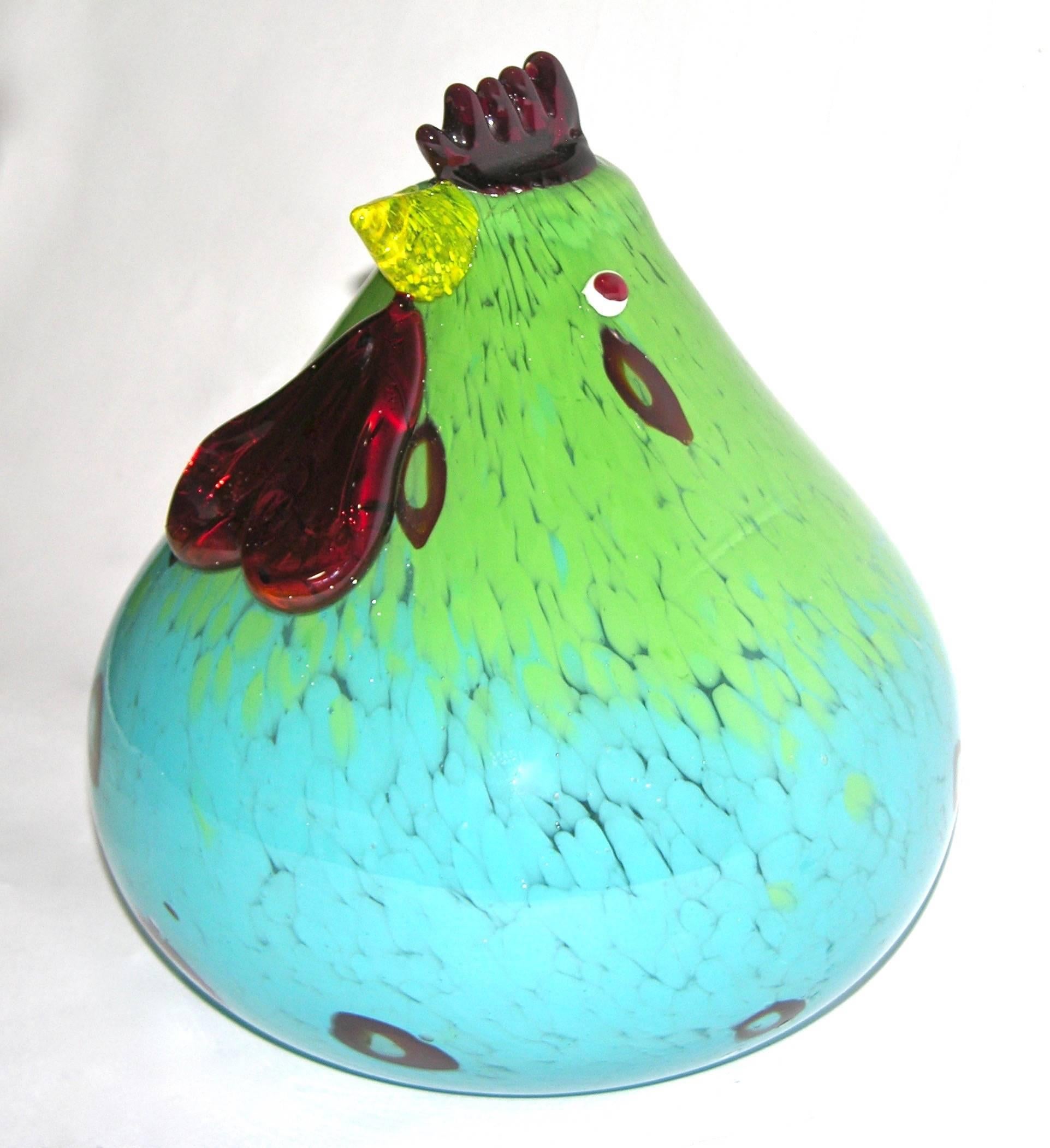 This fun cartoon style hen is in blown Murano glass with modern vivid colors, the turquoise aqua blue overlaid body is worked with extensive degrading apple green murrine and dark red highlights, enhanced by accents in relief: humorous white and red