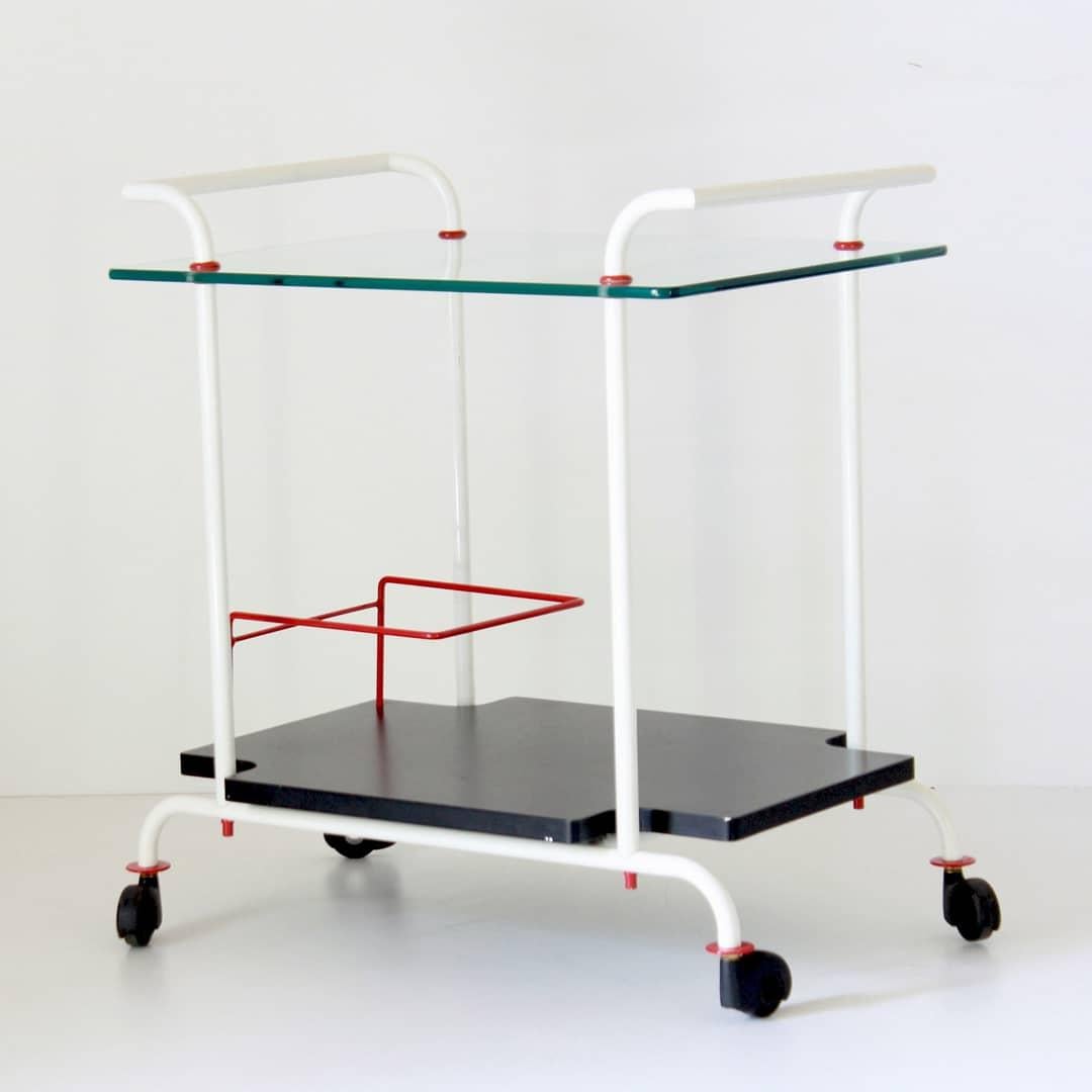 A 1980s vintage rolling bar cart with iron structure and double top. Top one in glass and bottom one in hard plastic.