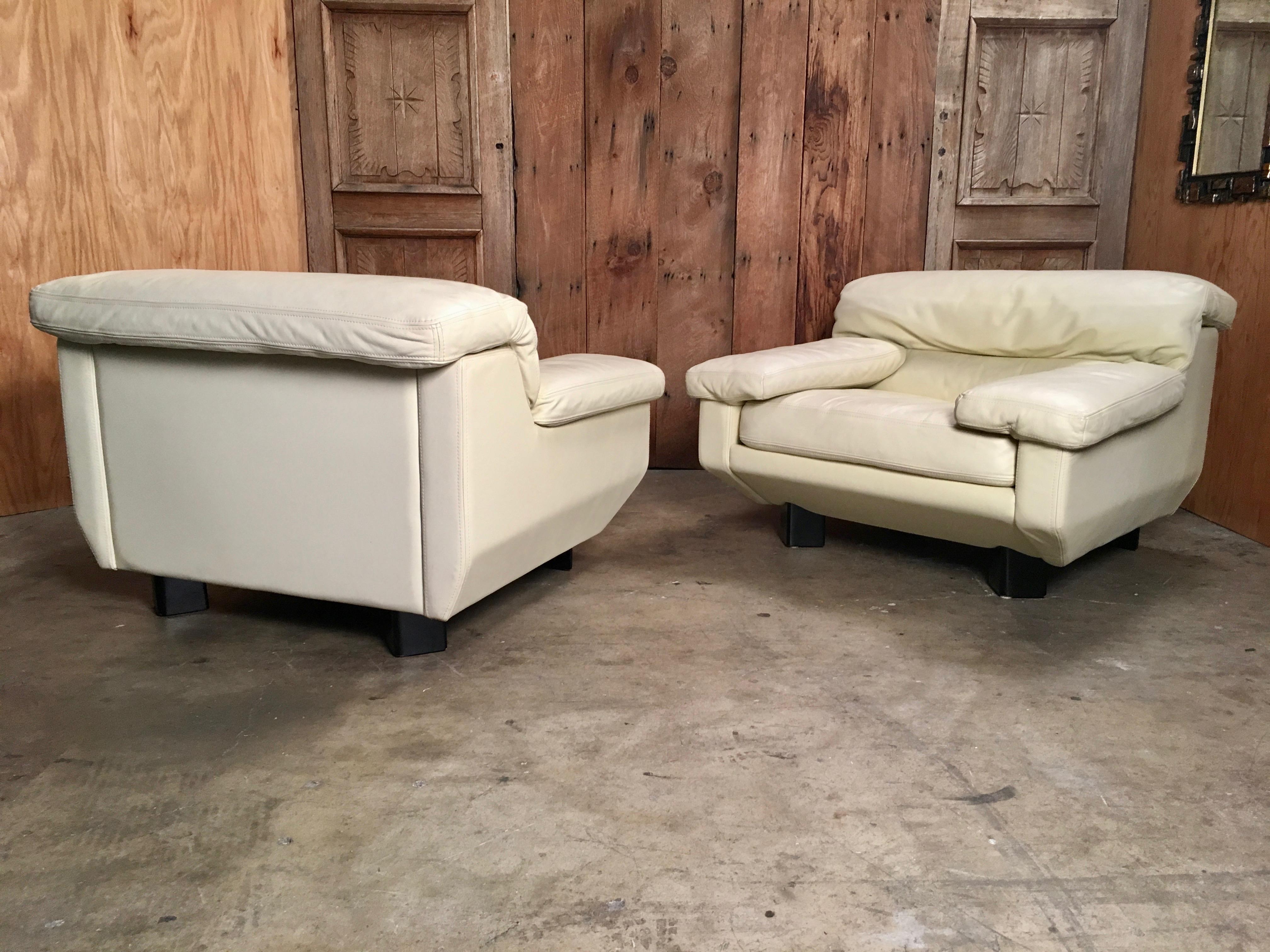 A pair of 1980s Italian leather lounge chairs with triangular feet and adjustable headrest in a off white leather from the 