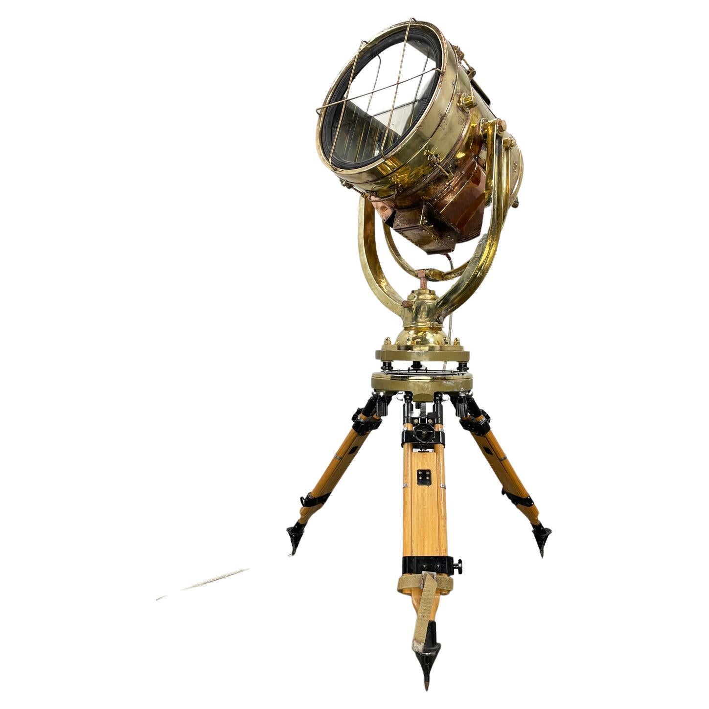 This is a Shonan Kosakusho daylight signalling lamp made in 1980 married with a military gyroscope tripod. 

Reclaimed from Mid-Century war ships, Shonan did manufacture these during World War 2 until the firestorm on Japan ceased production. The