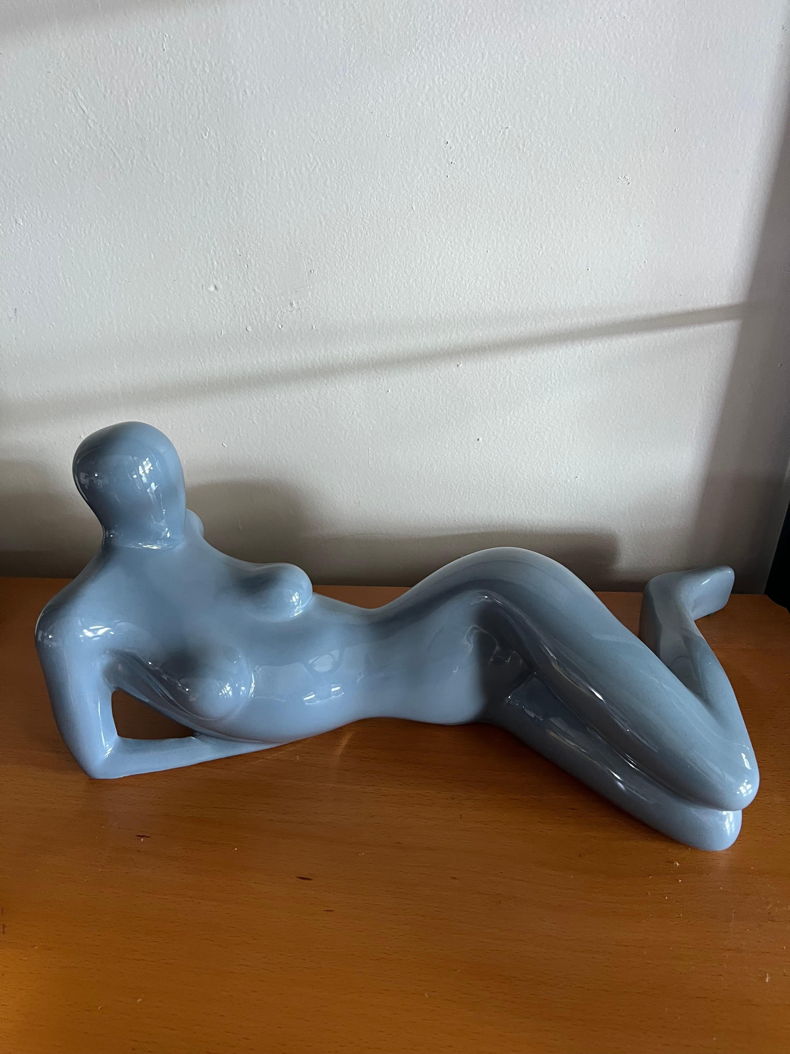 Une sculpture en céramique émaillée de ©Jaru en bleu. La sculpture représente une femme nue partiellement couchée sur le côté. La sculpture est un chef-d'œuvre visuel des deux côtés. Excellent état. Pas d'éclats ni de craquelures de la glaçure.