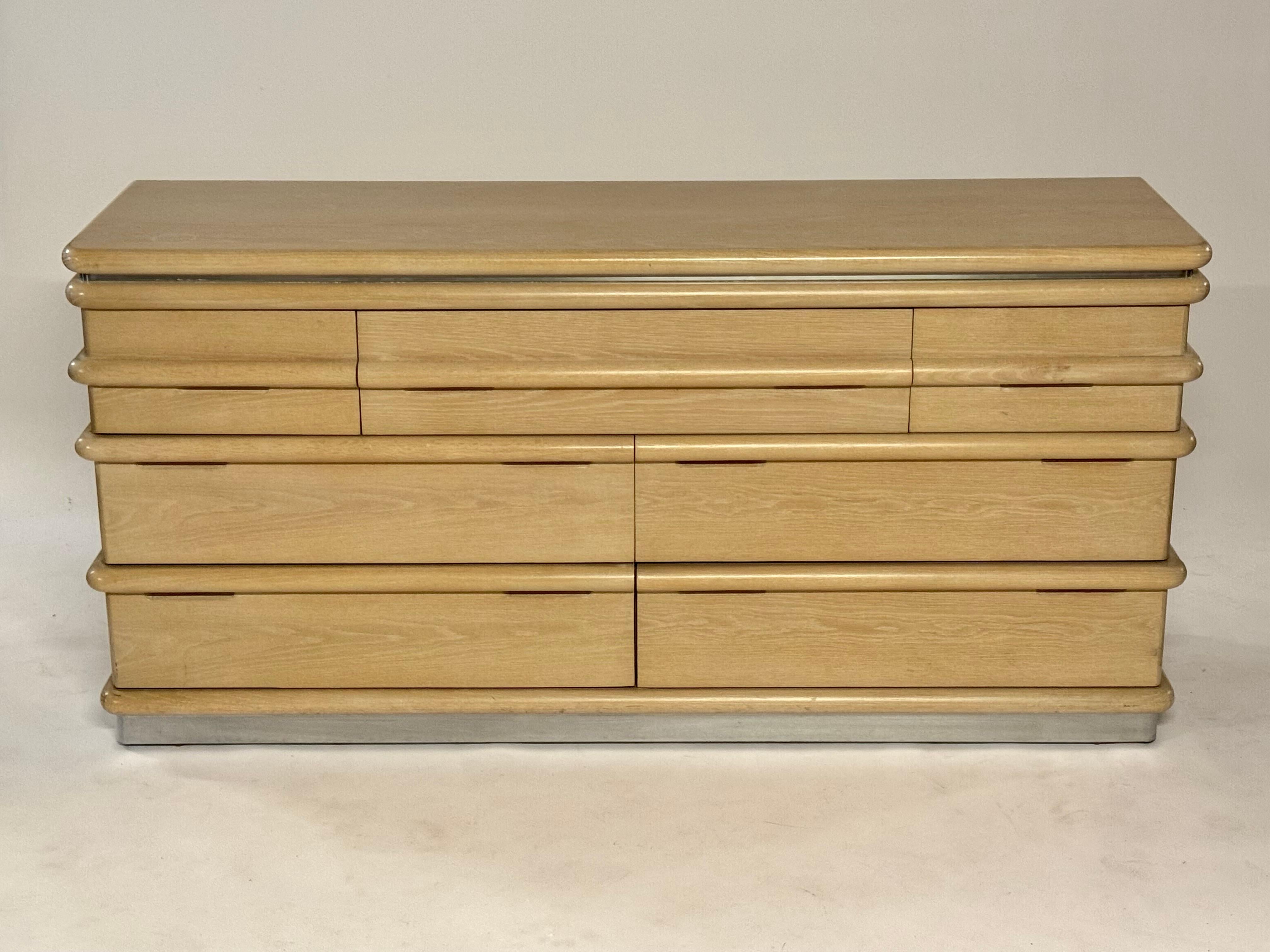 Jay Spectre celebrity interior designer of the 1980's designed bleached oak 7 drawer long dresser for Century Furniture.  Sprectre was heavily influenced by the Art Deco period, this dresser shows it, with wrap around bullnose drawer handles. Has