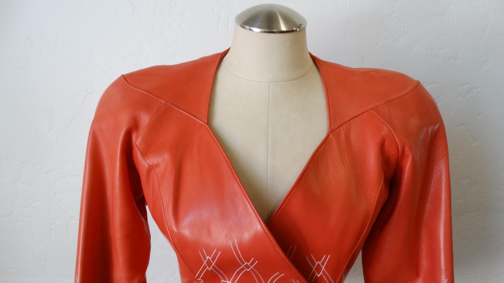 Feel All Of The 80s Vibes In This Leather Jacket! Circa 1980s, this Jean Claude Jitrois peach leather wrap jacket features strong shoulders, a sweetheart neck and a contrasting white stitched diamond pattern on the bottom half. Jacket wraps and