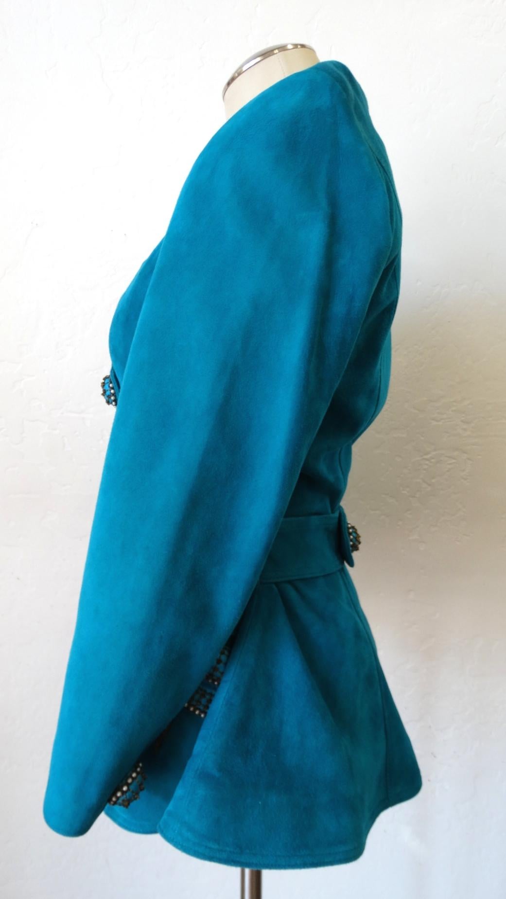 This Jacket Is Just Waiting To Be Worn! Circa 1980s, this Jean Claude teal suede leather double breasted jacket features a flattering sweetheart neckline and is decorated with embellished buttons and bows. The snap closure button and bow accents