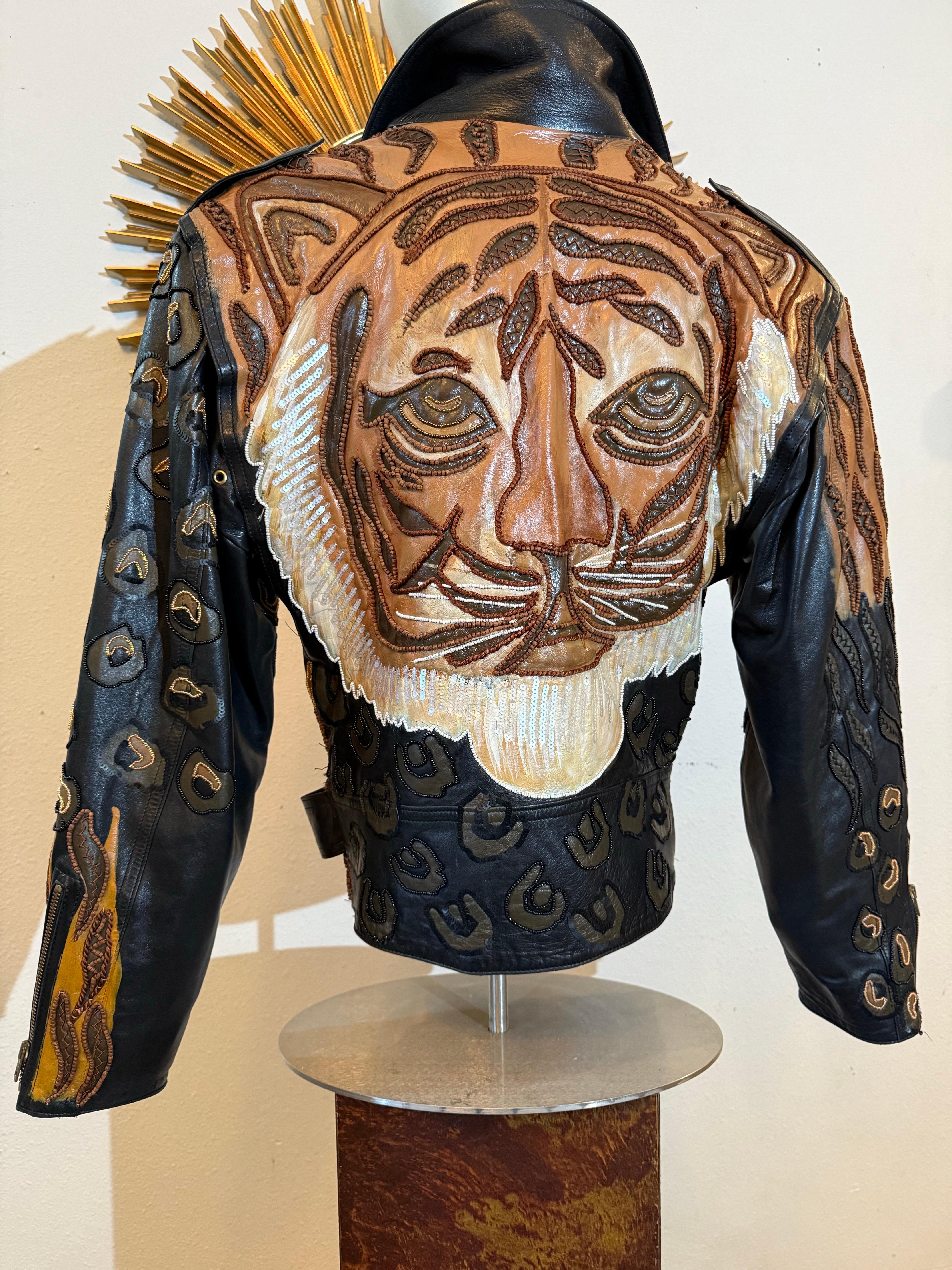 1980s Jean Claude Jitrois Leather Biker Jacket w Huge Painted Beaded Tiger Motif:  An oversized silhouette with a fitted waistline and a biker-style cut form the base for this rare and spectacular black lambskin jacket embellished on the back with a