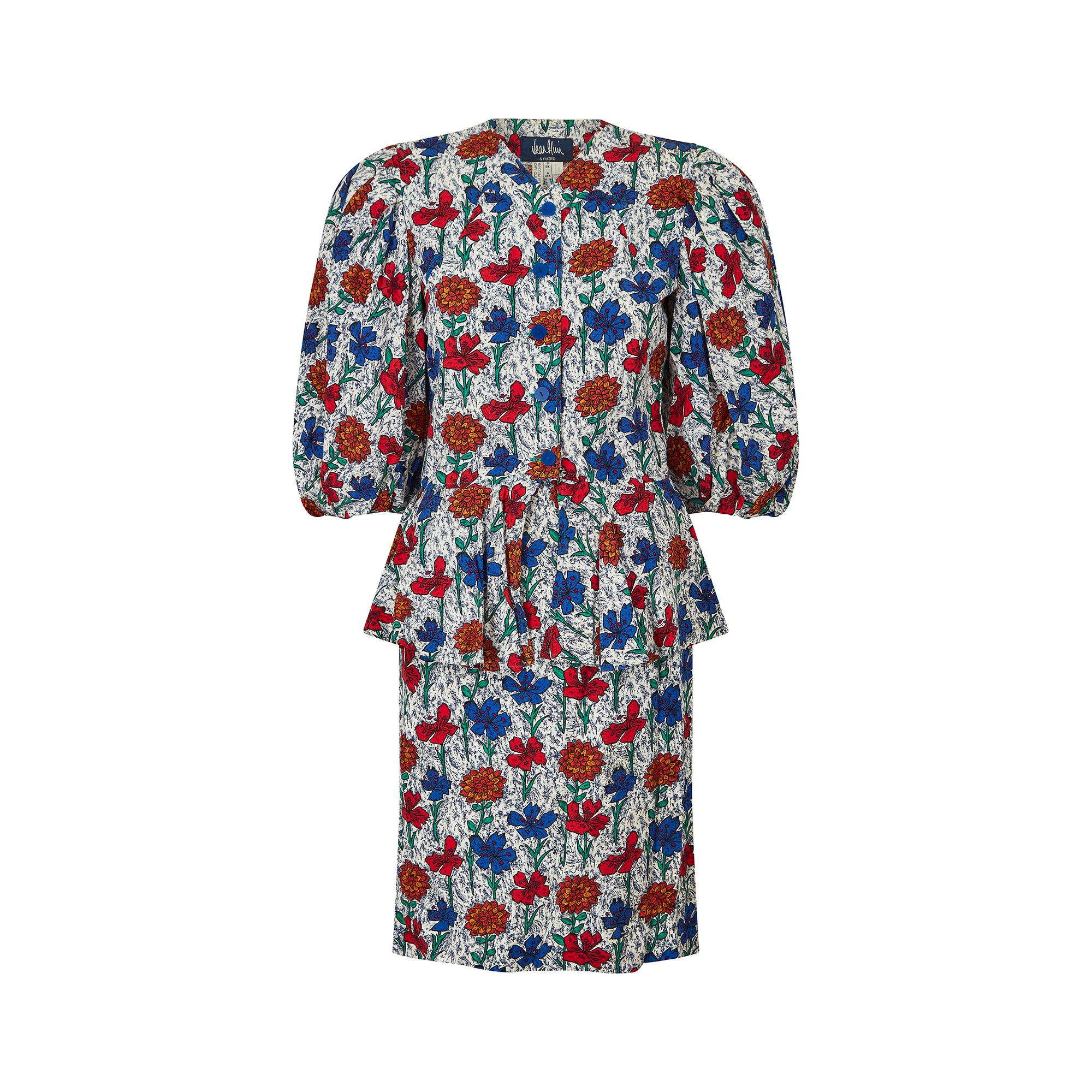 Vintage Jean Muir skirt suit from the mid to late 1980s. Both the skirt and the jacket are made using a brightly printed and lightweight viscose material, featuring bold blue, red and orange flowers against a mottled blue and white background. The