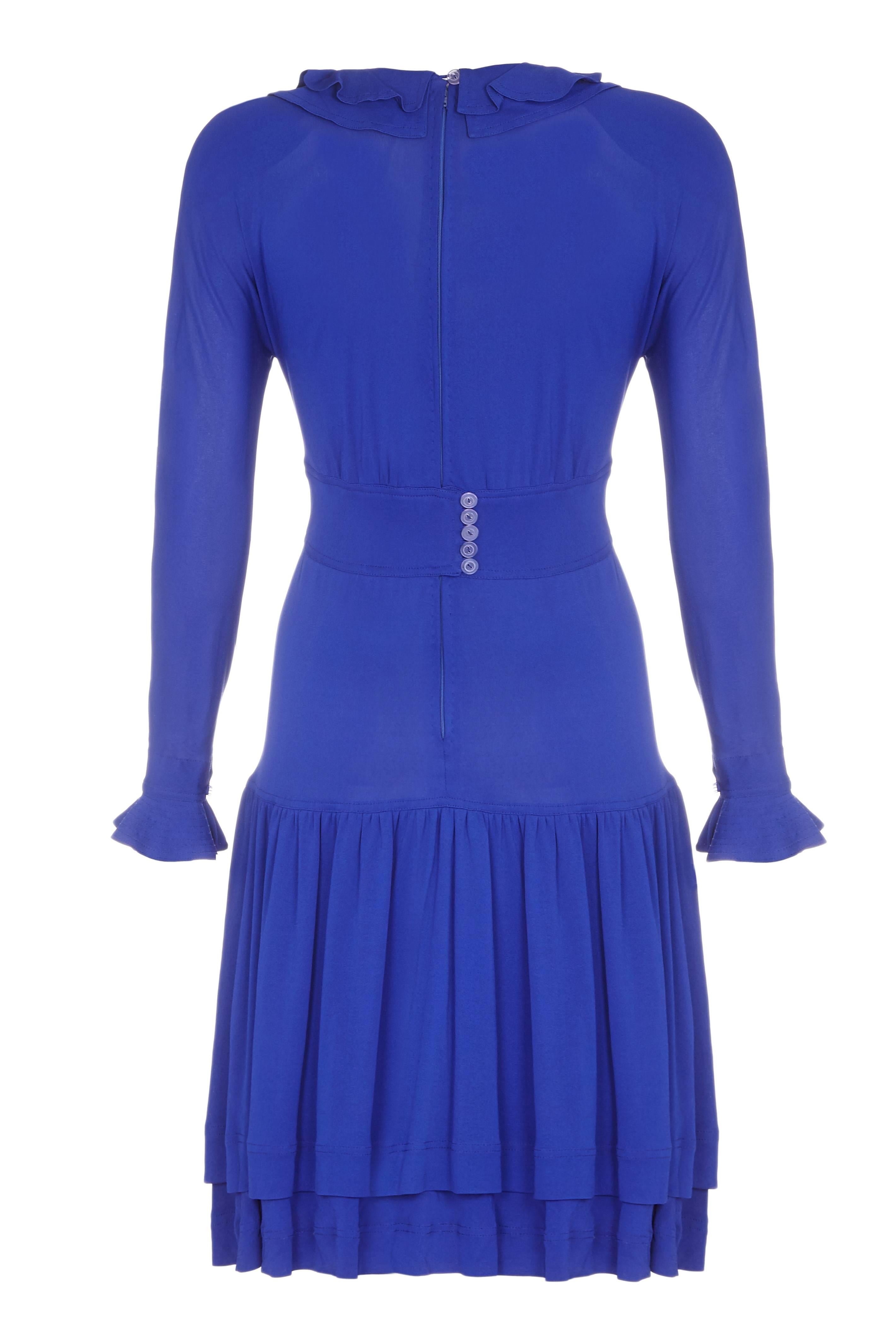 Cette robe en jersey bleu royal des années 1980 est signée de l'iconique designer britannique Jean Muir. Elle est en parfait état vintage et présente de jolis motifs. La robe est à manches longues avec une garniture à volants aux poignets et un