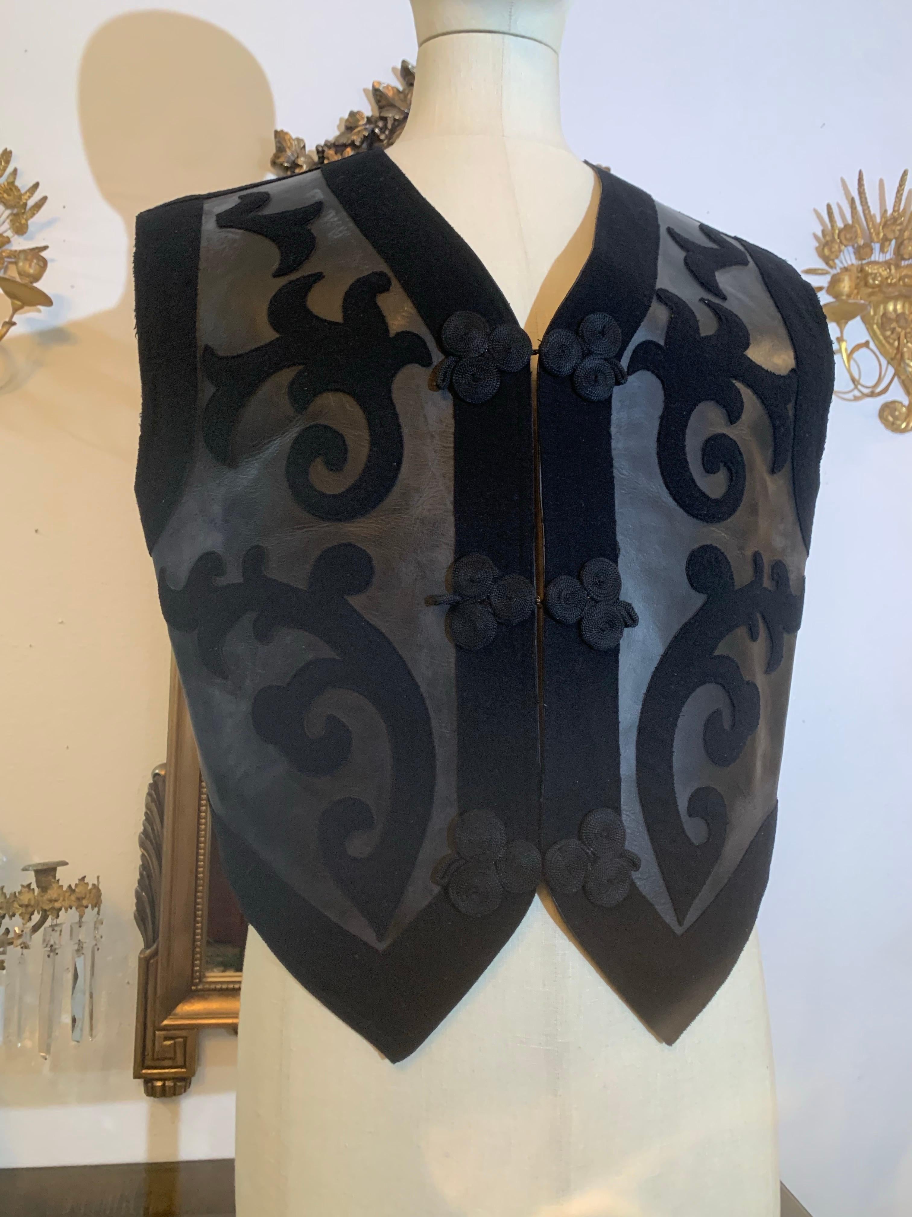 1980s Jean Paul Gaultier - Homme- Western-Inspired Black Saddle Leather & Wool Felt Vest with Buckle Back and Hook and Eye Closures. Heavy, Armor-Like Construction. Wool felt lined. A rare, early Jean-Paul design for his menswear line. 

Size EU 50. 