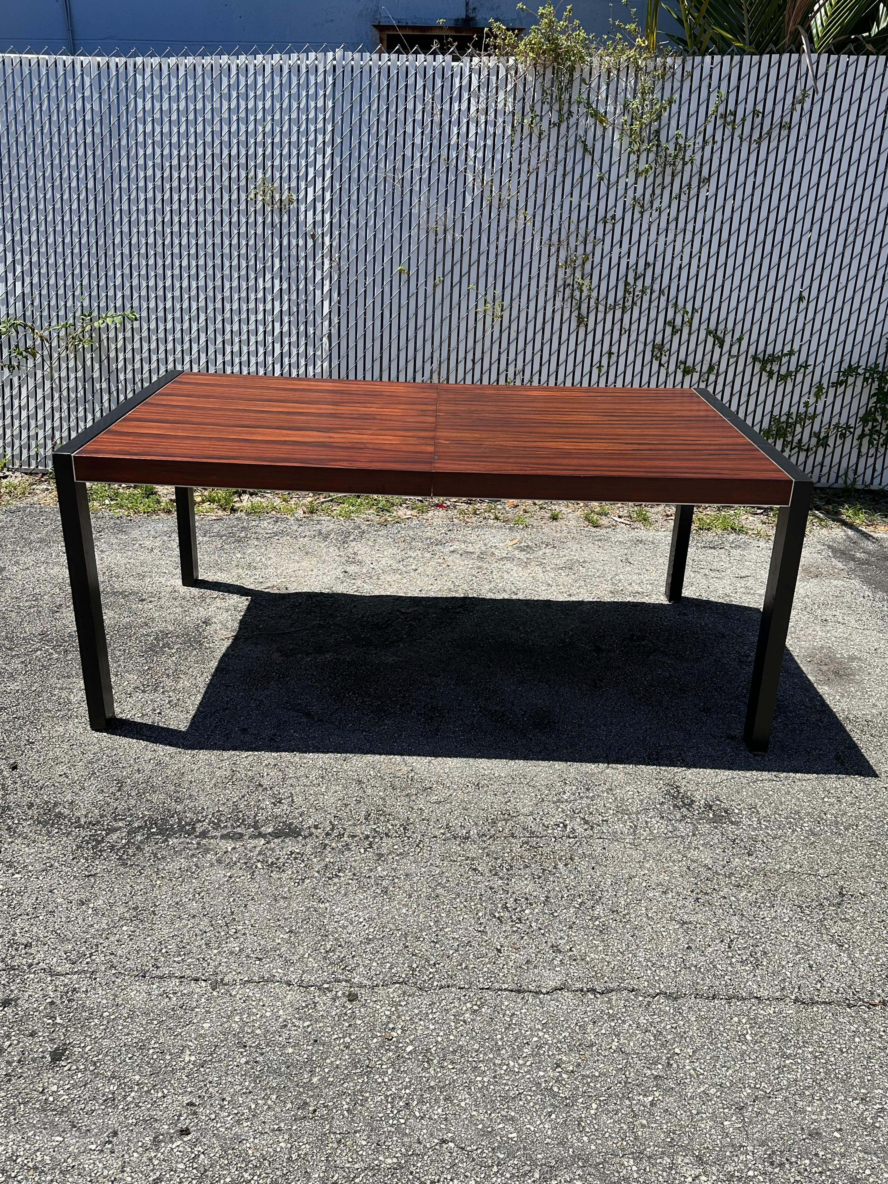 On offer on this occasion is one of the most stunning and rare, rosewood veneer with chrome trim dining table you could hope to find. In its original condition. No restoration. Outstanding design is exhibited throughout. The beautiful table is