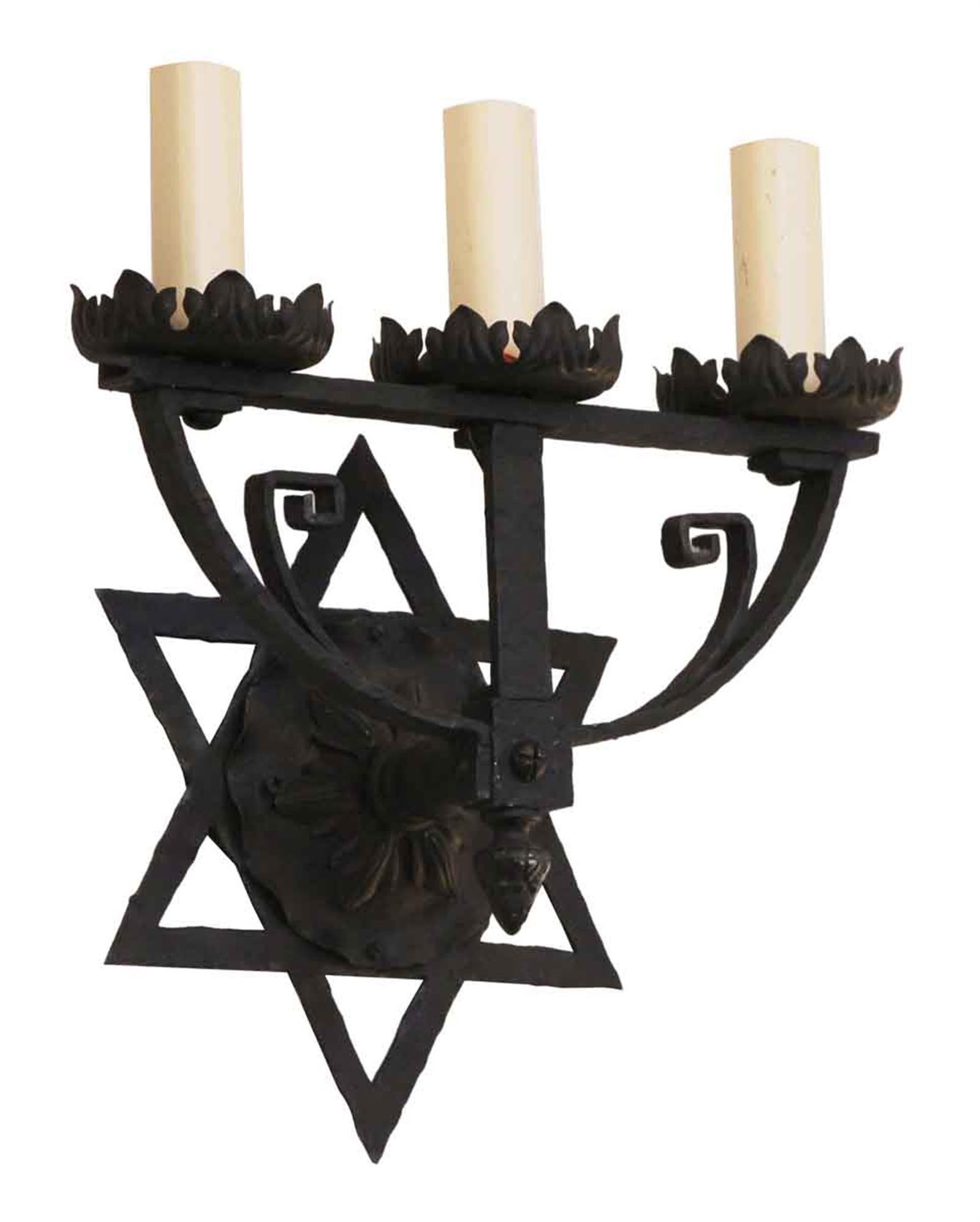 Wrought iron Star of David sconce with three candlestick lights and a black finish from the 1980s. This can be seen at our 2420 Broadway location on the upper west side in Manhattan.