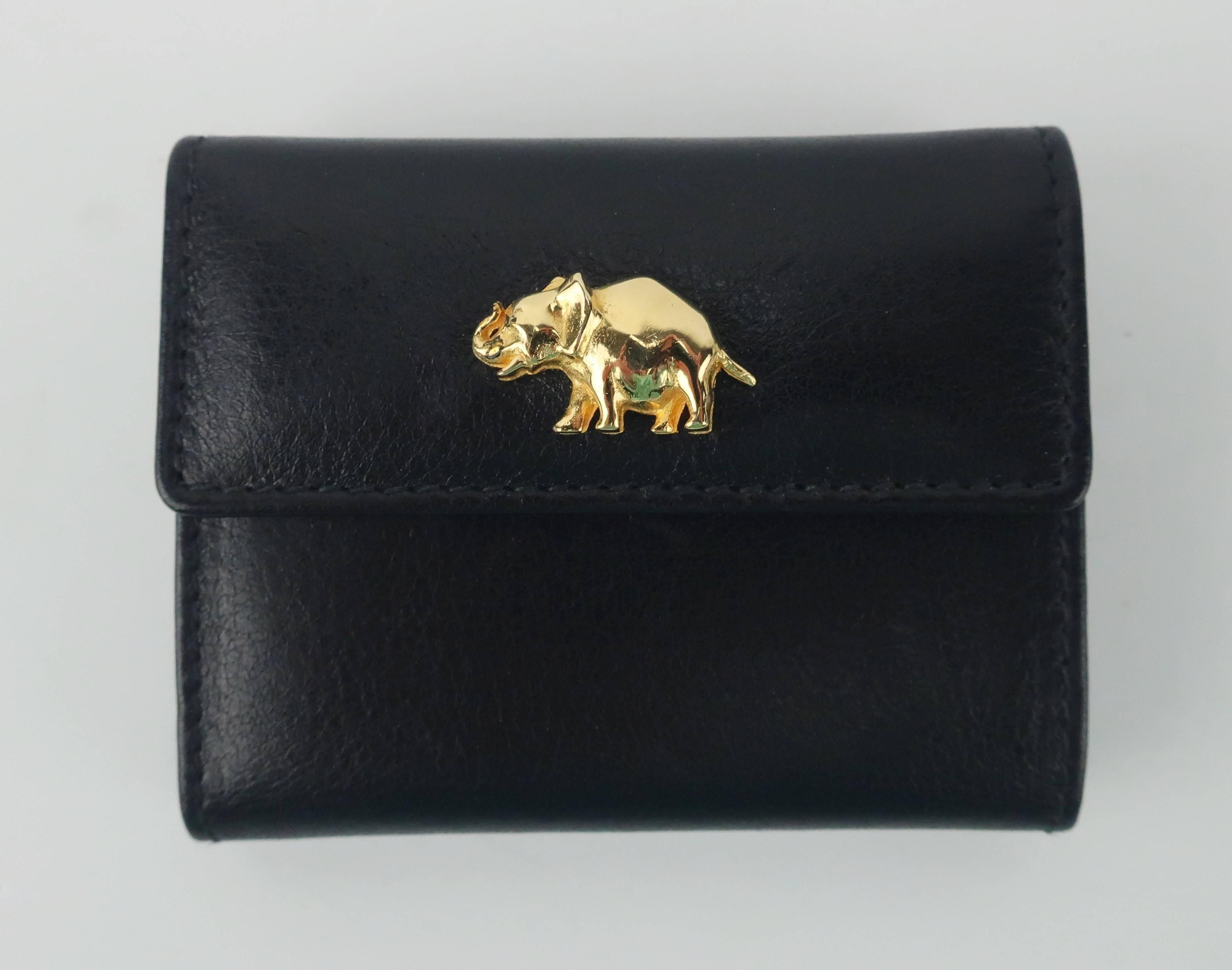 Elegant elephant!  This small scale Judith Leiber black leather wallet is a tri-fold design just big enough for a couple of bills with a fold open coin purse attached.  The wallet snaps in front and back for each compartment and there is an interior