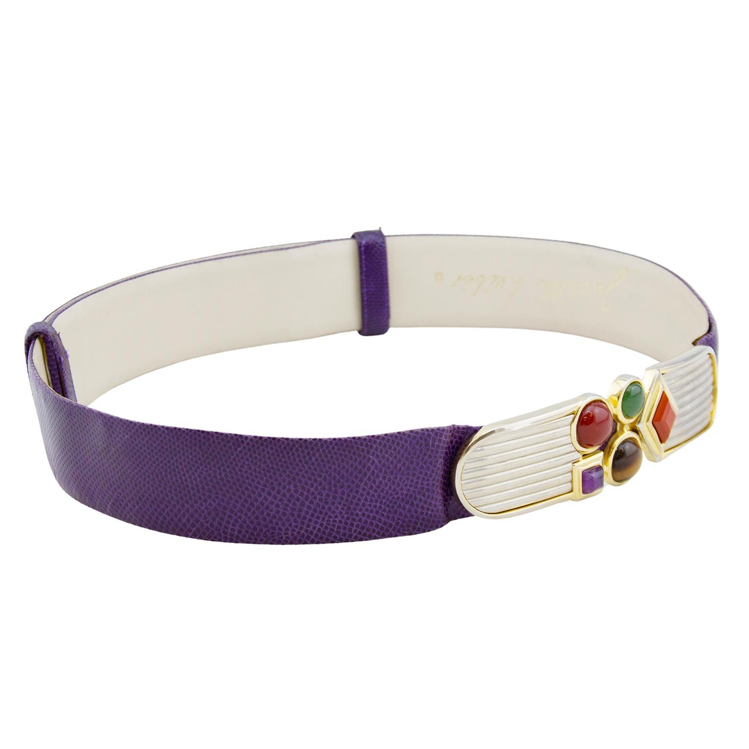 1980s Judith Leiber rich jewel toned purple patterned leather belt. Art Deco silver metal details at buckle with gold tone trim. Purple, green, orange, brown and red geometric cabochons in gold tone metal settings. Buckle closure is metal hook and