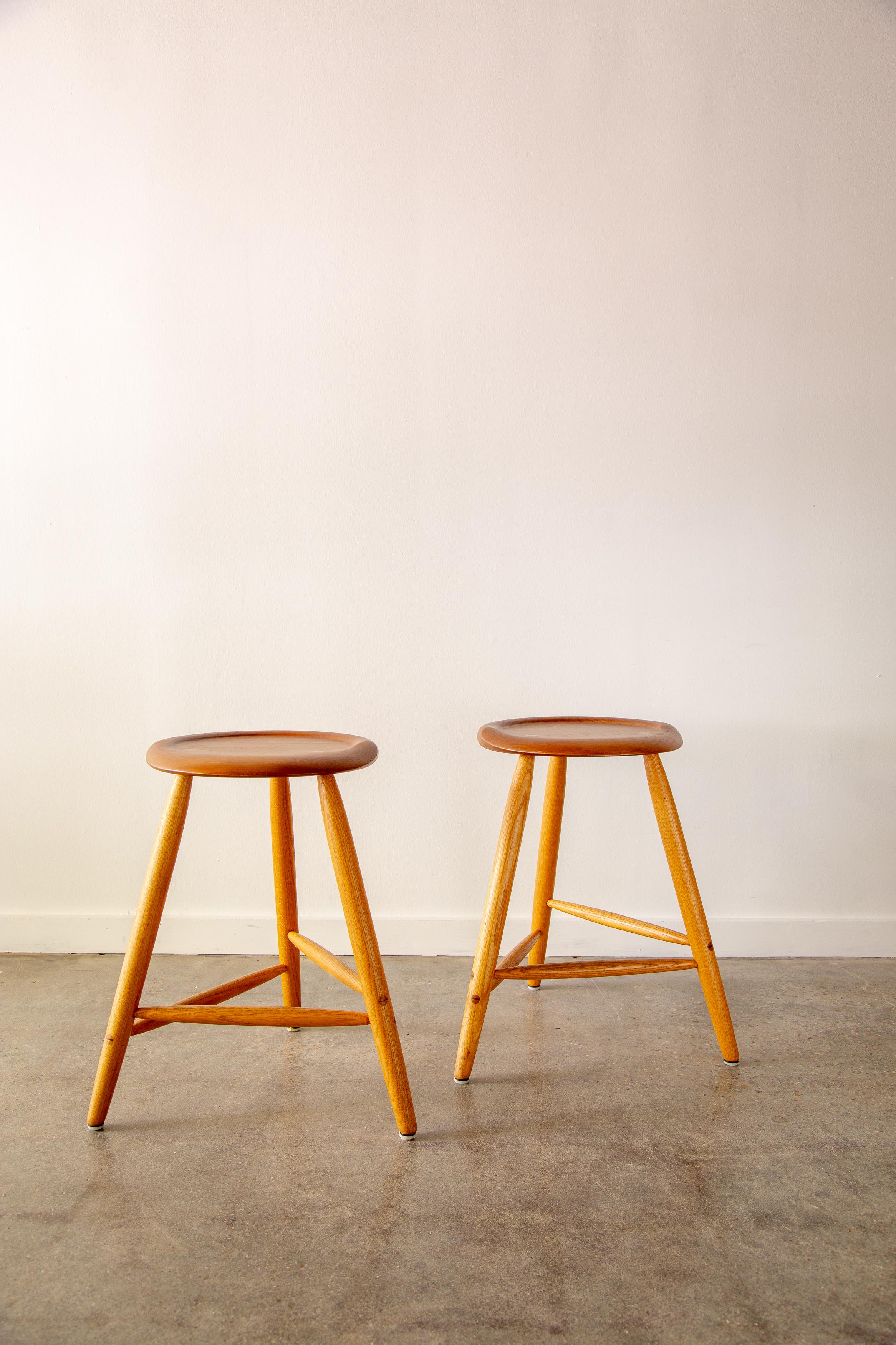 A pair of 1980s counter height stools by Kai Pedersen.  Sculpted seats of solid cherry on three ash legs.  Designed and made at Kai Pedersen Studios in 1991. Handcrafted by Kai Pedersen near new hope Pennsylvania. Sculpted seats, bent plywood backs,