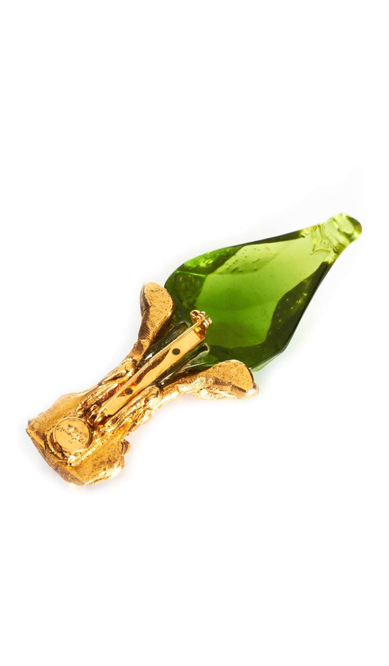 An impressive and unusual brooch in the shape of a torch from French couture brand Kalinger.  This piece is typical of their 1980’s style and is made up of green resin, which has been partly gold plated to form the base. Three rhinestones decorate