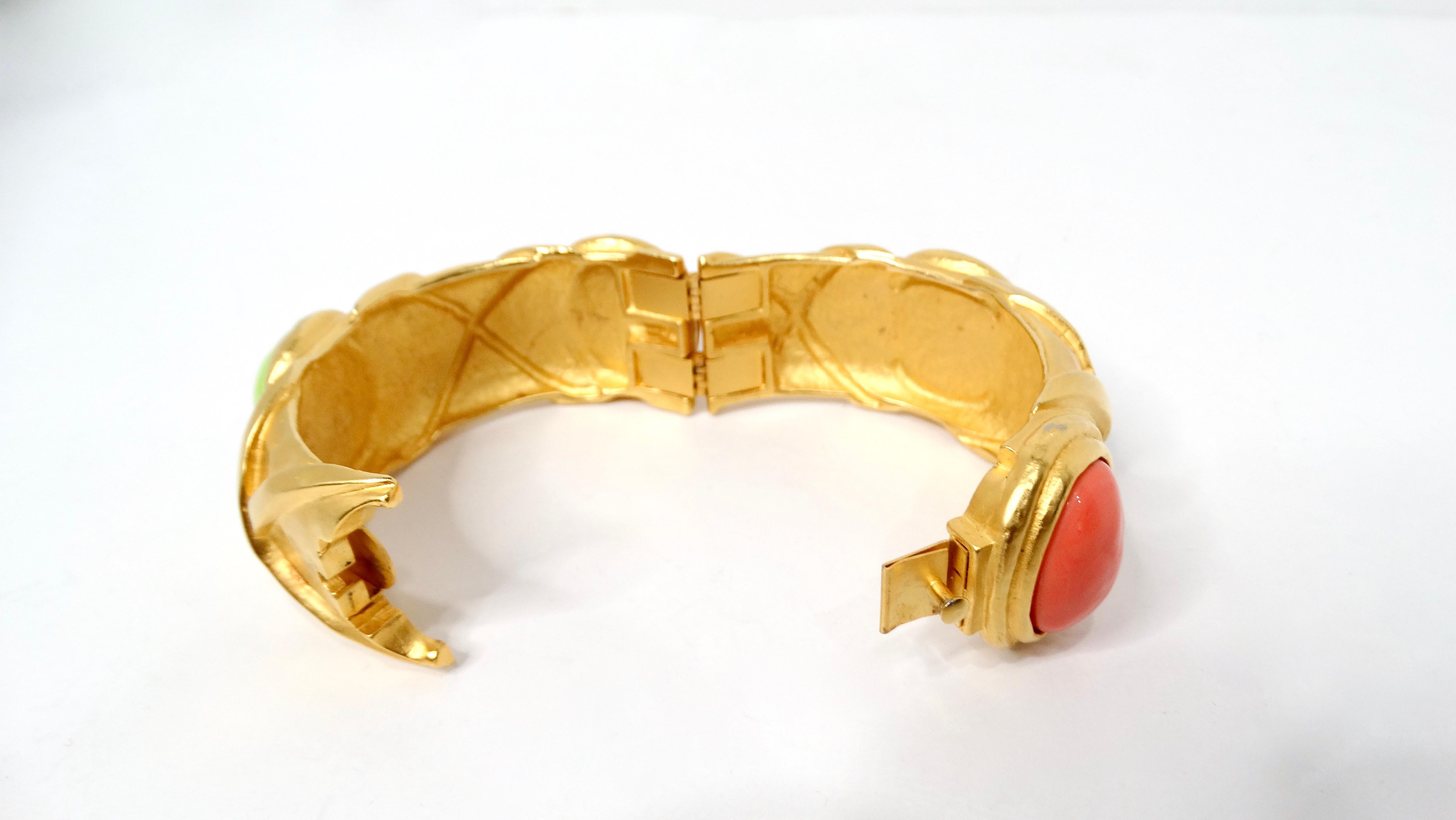 Embrace the bold statement of the 1980s with this exquisite Karl Lagerfeld 18k Gold Plated & Costume Stone Textured Cuff Bracelet. This unique piece features two stunning costume green stones and two captivating costume coral stones, beautifully set