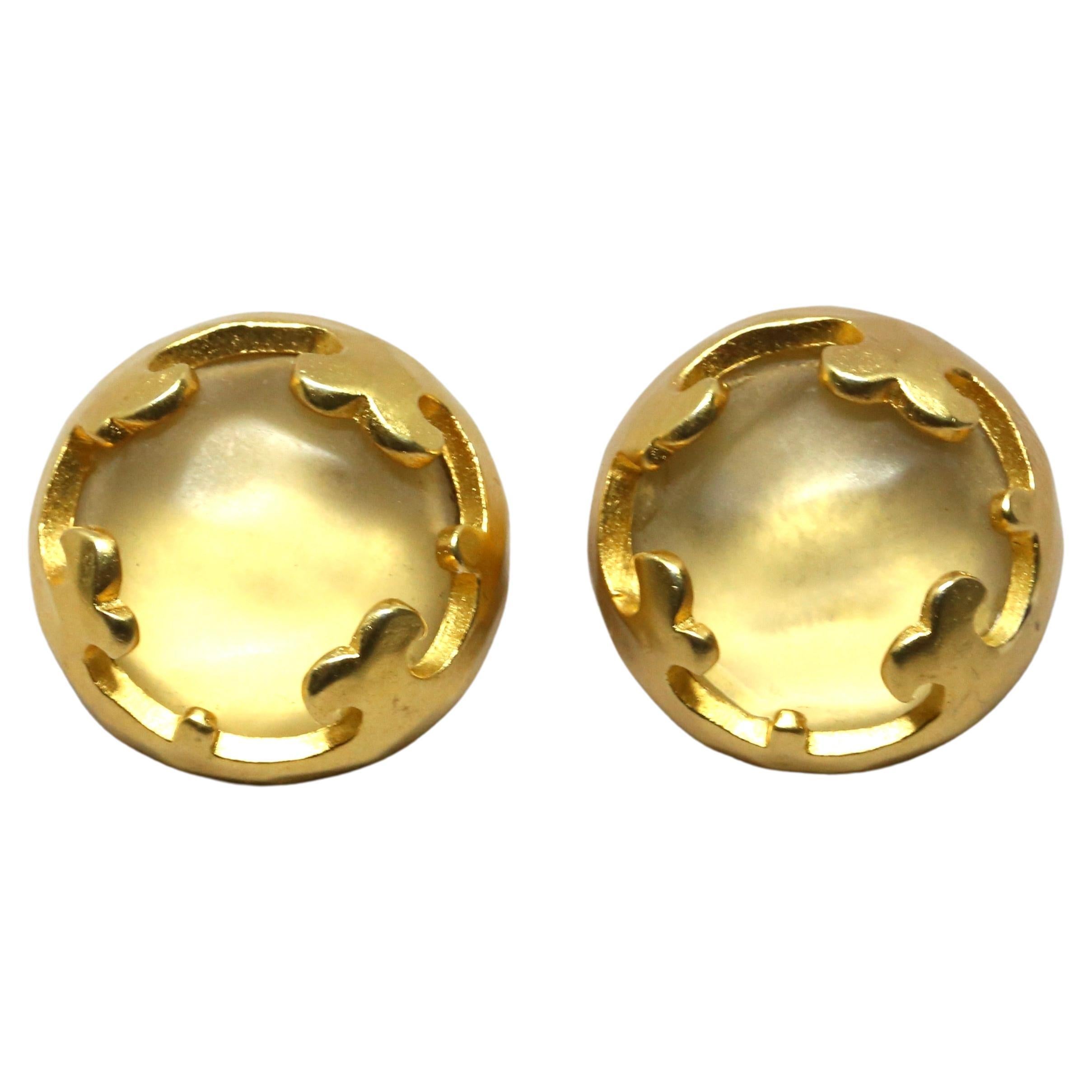 Matte-goldtone, pierced earrings with frosted cabochon stones from Karl Lagerfeld dating to the 1980's. Approximate measurement: 1