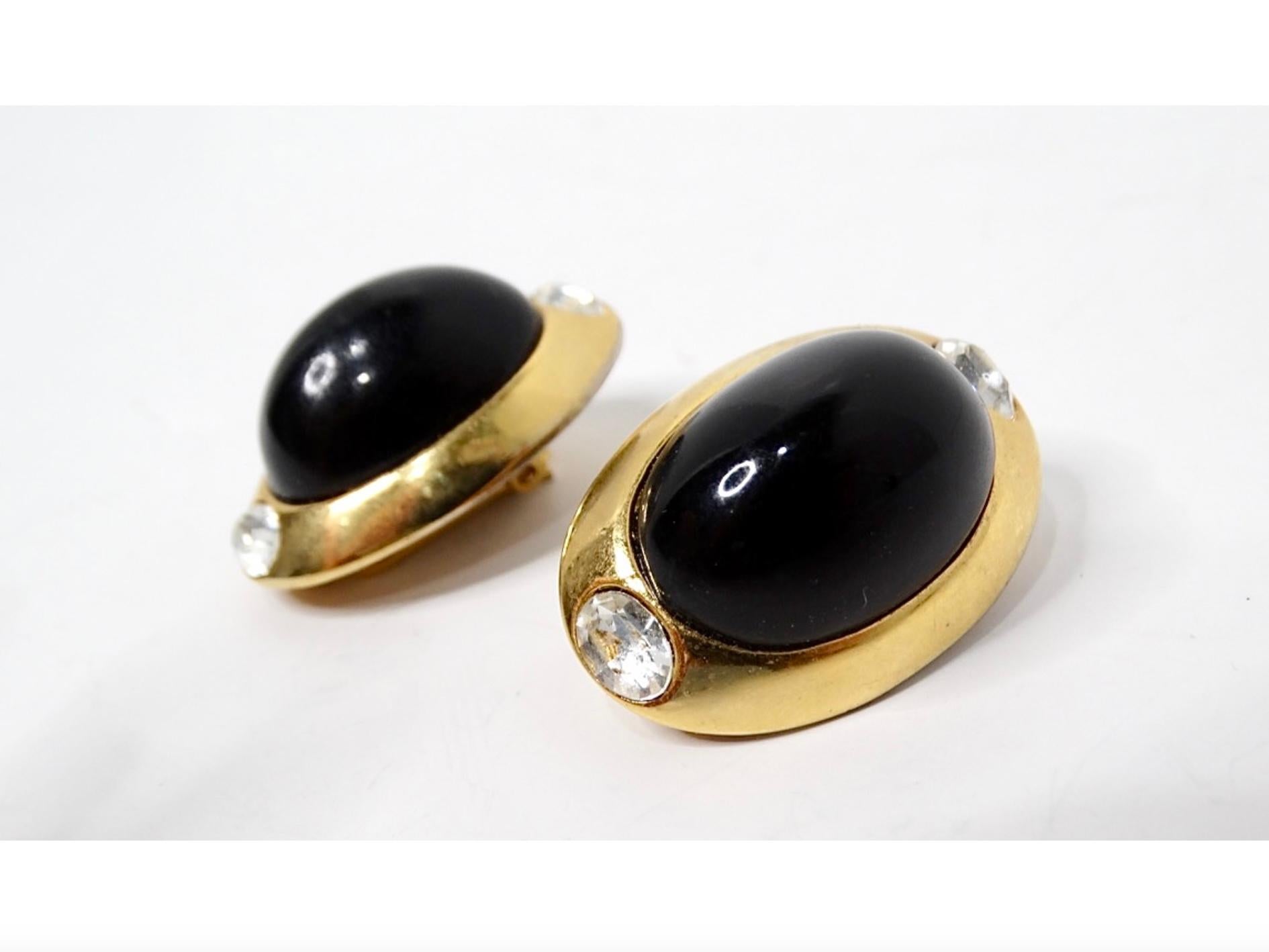 Eleva la tua collezione di accessori con questi splendidi orecchini a clip in tonalità oro con cabochon nero di Kenneth Jay Lane, risalenti agli anni Ottanta. Eleganza senza tempo, questi orecchini ovali sono caratterizzati da un sorprendente