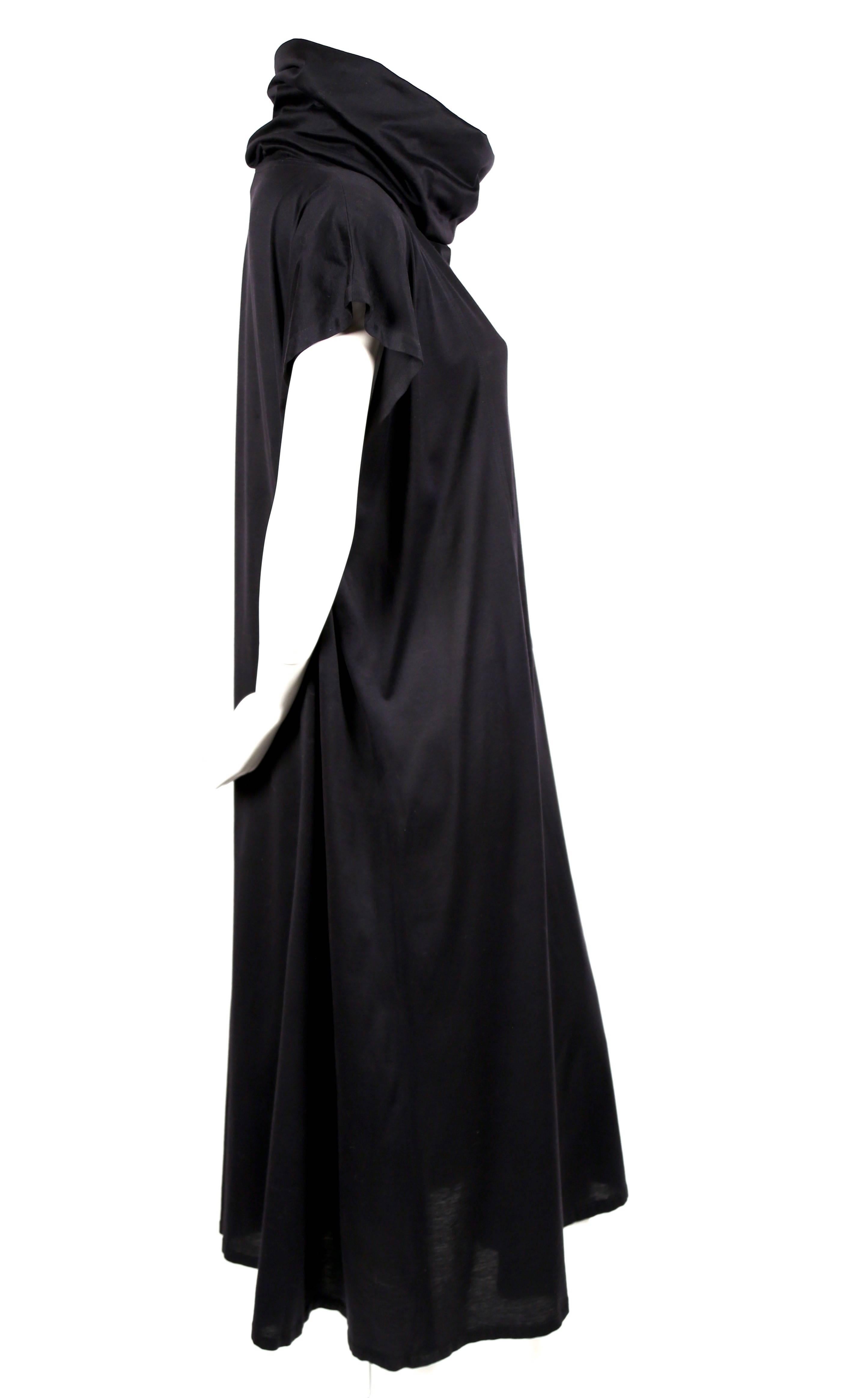 Jet black fine gauge cotton jersey dress with cowl neckline and angled patch pocket at front designed by Kenzo Takada dating to 1985 as seen on the spring summer runway. Dress is labeled a French size 36 however due to the loose cut it can