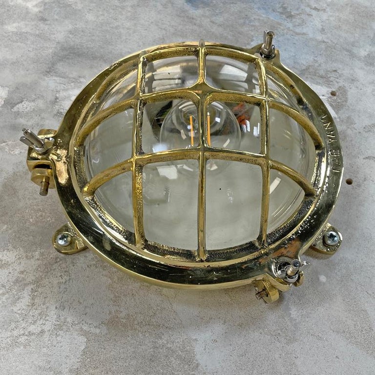 Late 20th Century 1980's Korean Brass Circular Bulkhead Light with Cast Cage and Glass Shade For Sale