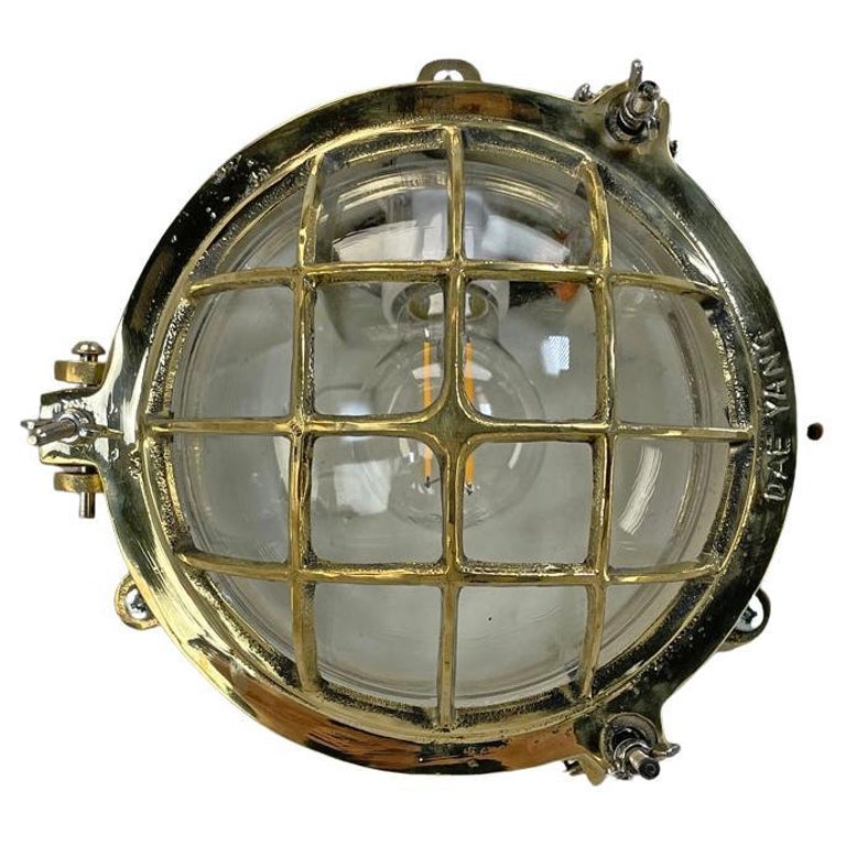 1980's Korean Brass Circular Bulkhead Light with Cast Cage and Glass Shade For Sale
