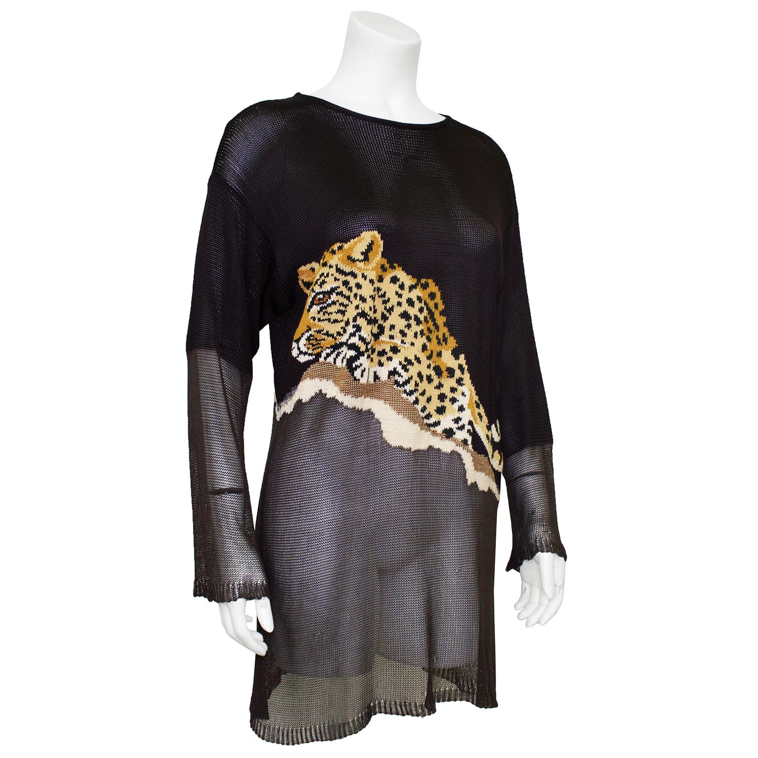 Krizia tunic length sweater from the 1980s. Sheer dark chocolate brown knit with a large illustration of a leopard laying on an asymmetrical ledge. Below the illustration, the sweater cascades into a thinner open knit that is more see through. The