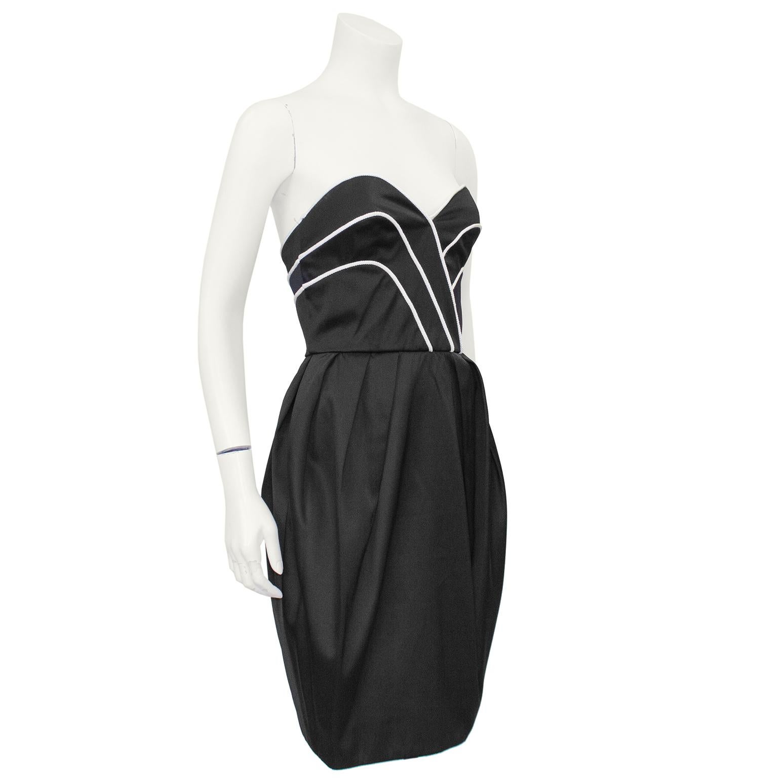 Timeless Lanvin black satin strapless cocktail dress from the 1980s. The sweetheart neckline and upper bodice are trimmed with a cream rope detail that accentuates the natural curve of the bustline. The bubble style skirt is achieved with inverted