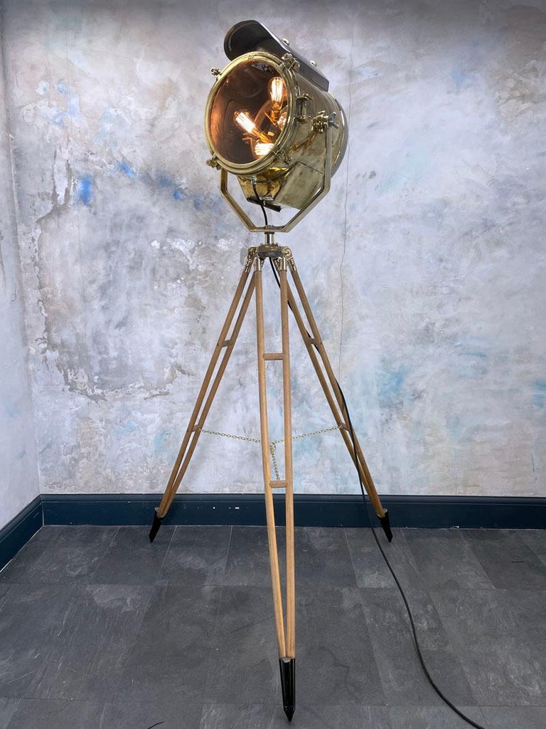 A reclaimed vintage nautical brass and steel search light mounted onto a British antique surveyors tripod to make a bespoke floor lamp

The Lamp head is constructed of pressed brass, steel and tempered glass, the electrics have been fully modified