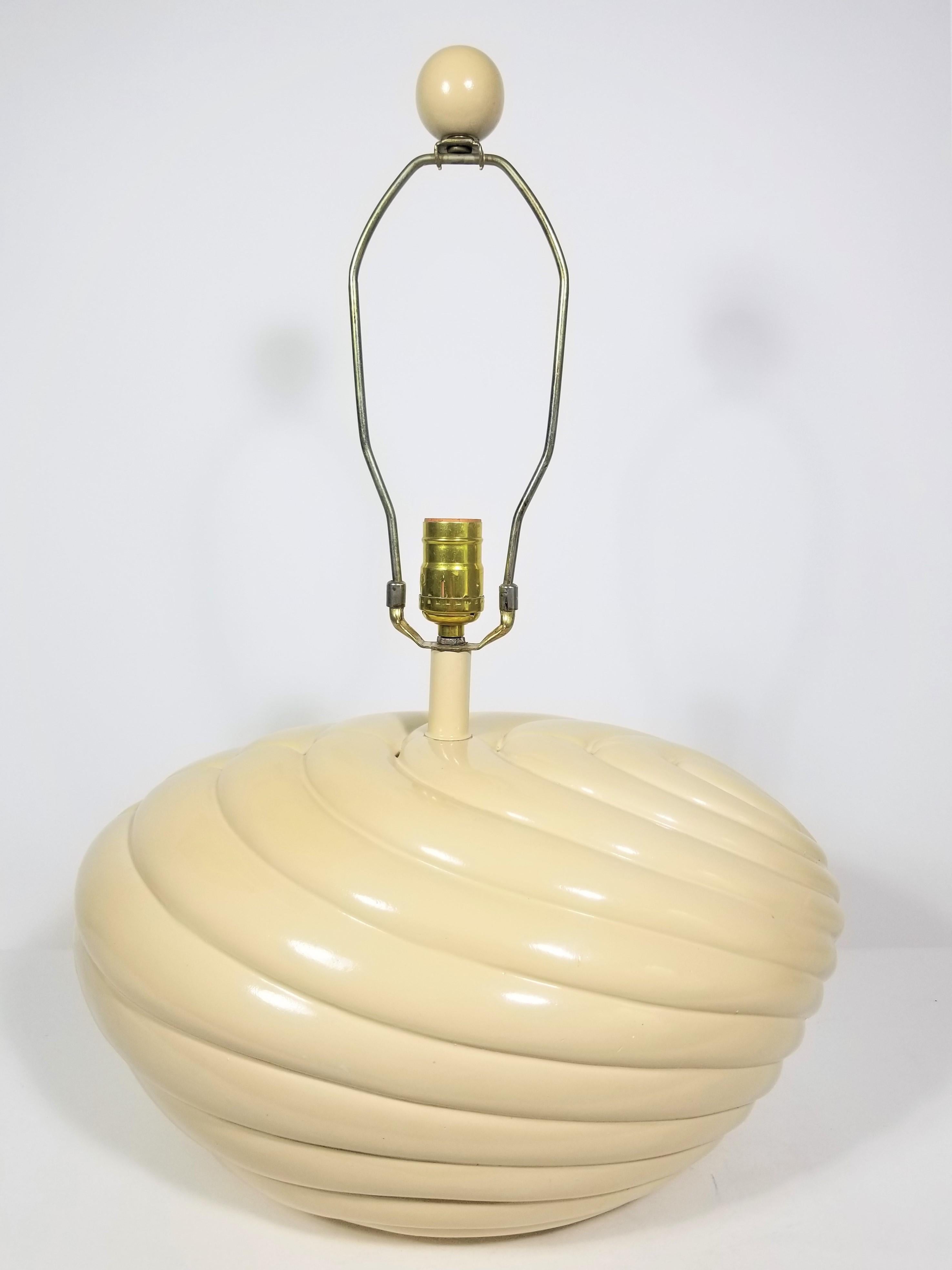 1970s-1980s midcentury bulbous base lamp. Off white color. Shell inspired design. Matching wooden round ball finial. Heavy weight. 
Lamp Measurements:
Height to top of finial: 23.0 inches
Height to top of socket: 14.0 inches
Height to top of lamp