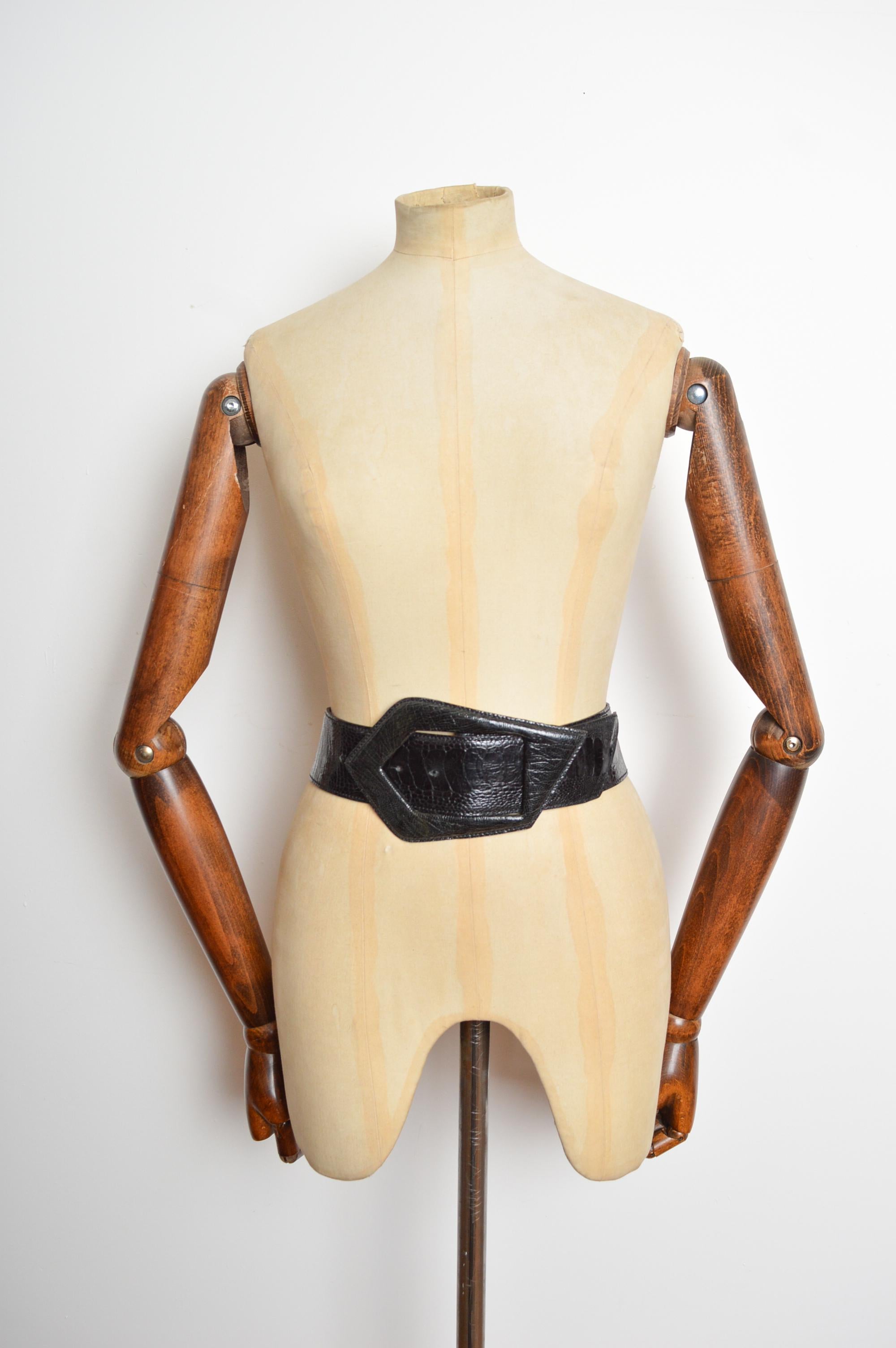 Una favolosa cintura artigianale degli anni '80, con guardia in vita. Realizzate in pelle di struzzo nera lucida e liscia, presentano una grande fibbia geometrica. 
Proveniente dal centro di Parigi, in Francia.
Le misure sono indicate in pollici