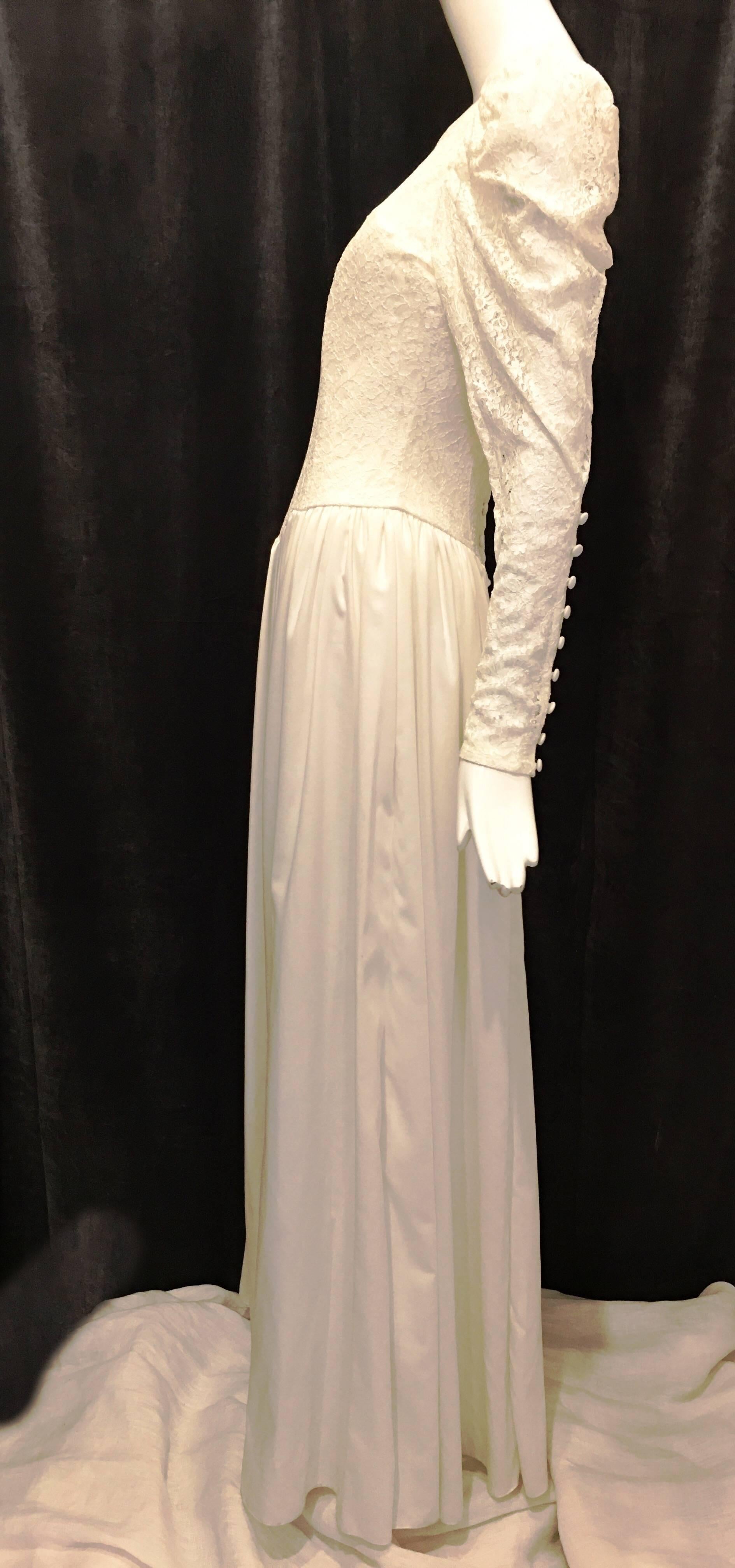 Lace bodice wedding dress with sheer lace arms and princess sleeves. 9 functional buttons at wrists of sleeves. 7 buttons at back of dress. Back is v cut above the buttons. Strapless ribbed bodice beneath lace at front of dress. Neckline slightly