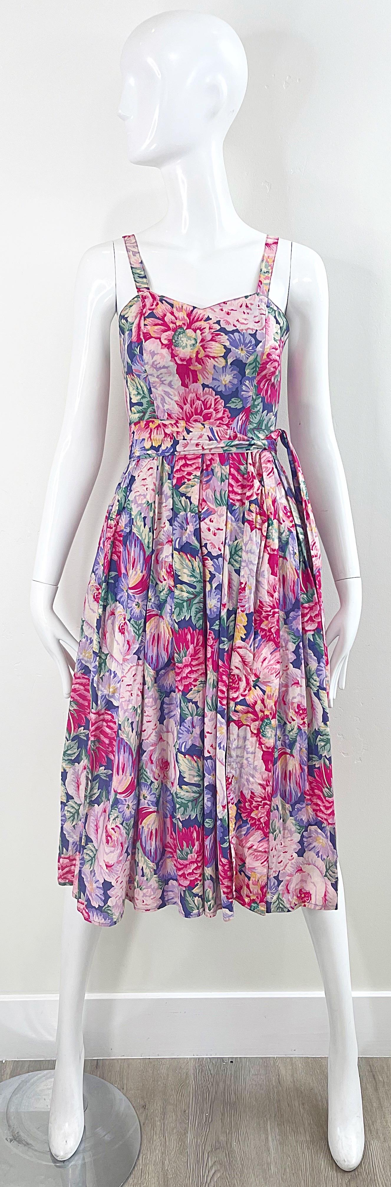 Chic and pretty early 80s does 50s LAURA ASHLEY sleeveless cotton floral dress ! Features large printed flowers in purple, pink, green, yellow and white. Detachable matching belt. Pockets at each side of the hips. Hidden zipper up the back with