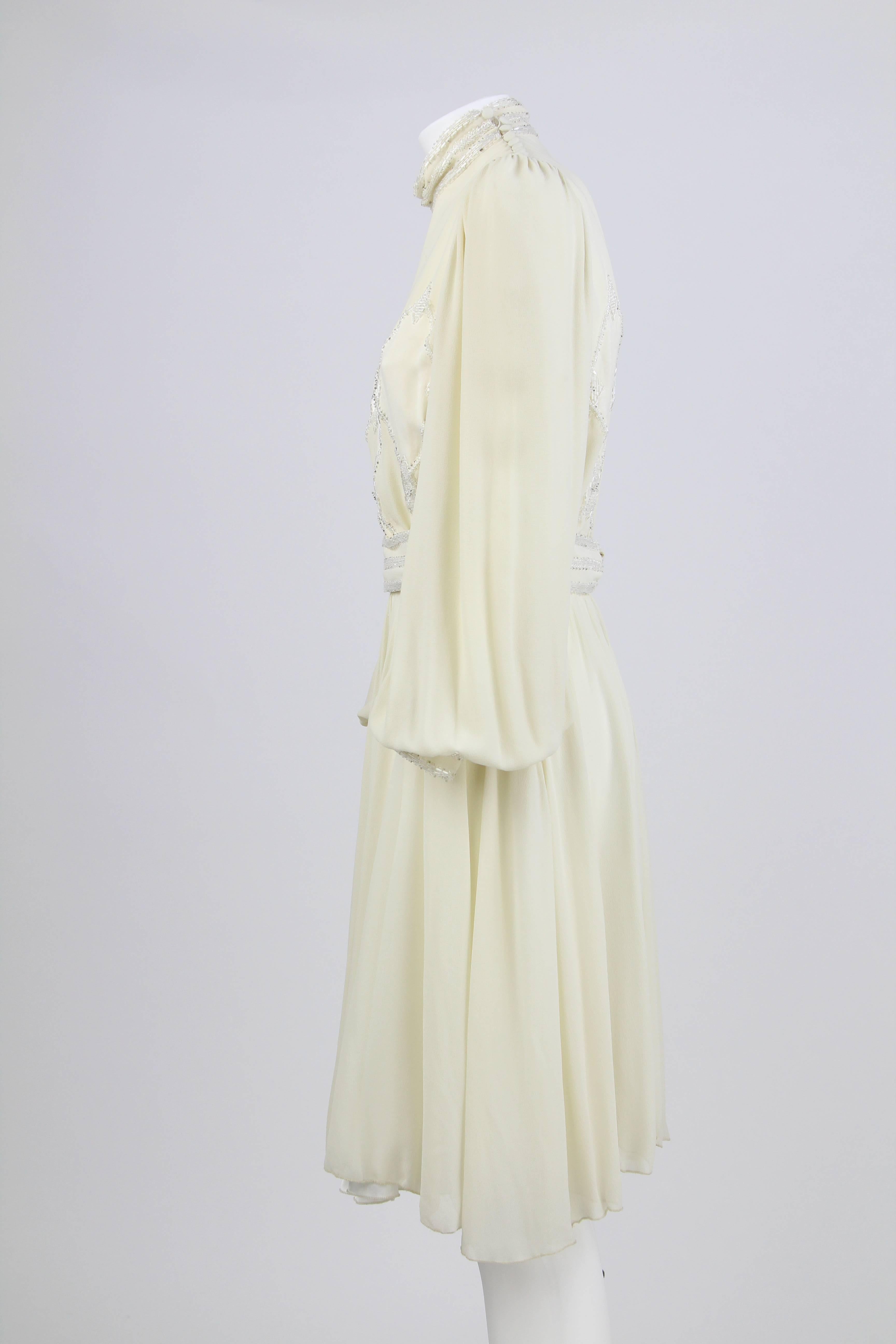 Charming cream white silk long sleeved dress made by Leggenda made in Italy. It features pearly white beads decorations on the bodice, the collar, the cuffs and the removable waistband.  The dress has a petticoat. There's a zip on the left side and