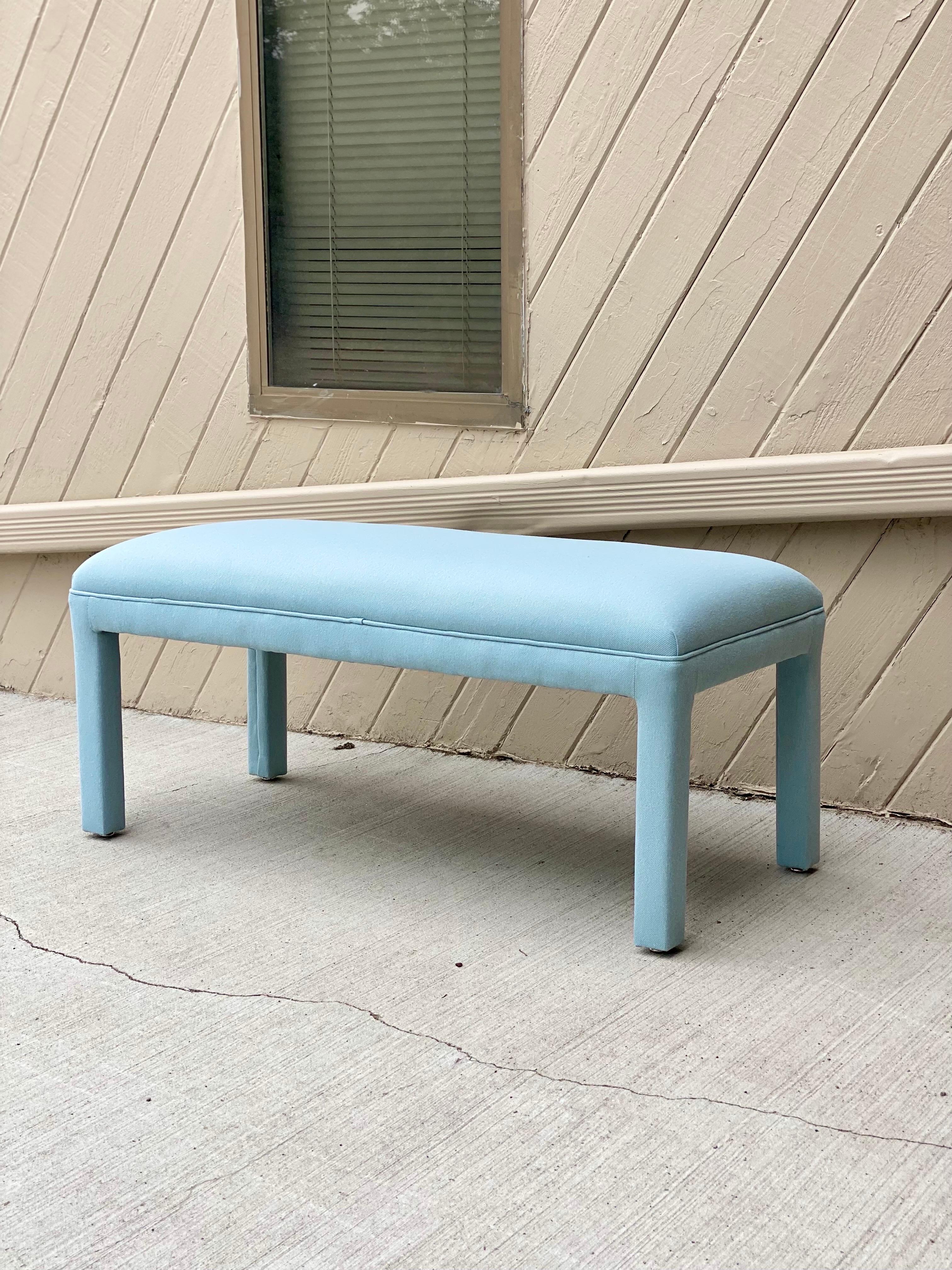 We are very pleased to offer a stylish Parsons bench, circa the 1980s. Add extra seating to your entryway or hallway with this gorgeous bench reupholstered in a soft and beautiful light blue fabric. This streamlined piece features a compact modern