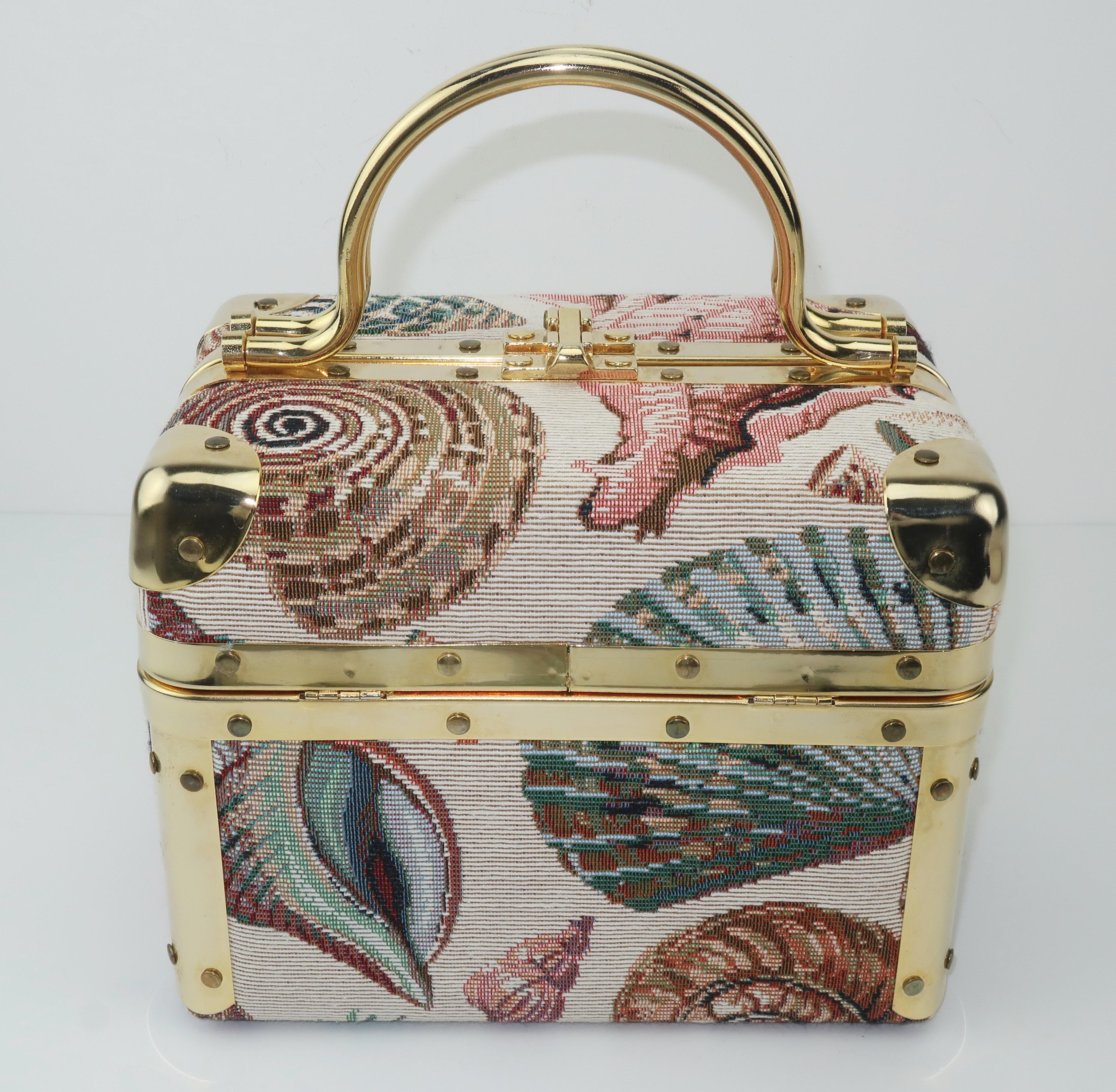 Fun and functional Lisette of New York train case style handbag with a gold tone metal frame and a seashell motif tapestry fabric.  The swivel handles part to reveal a hammer style clip closure.  Both sides of the top are hinged and open to a faille