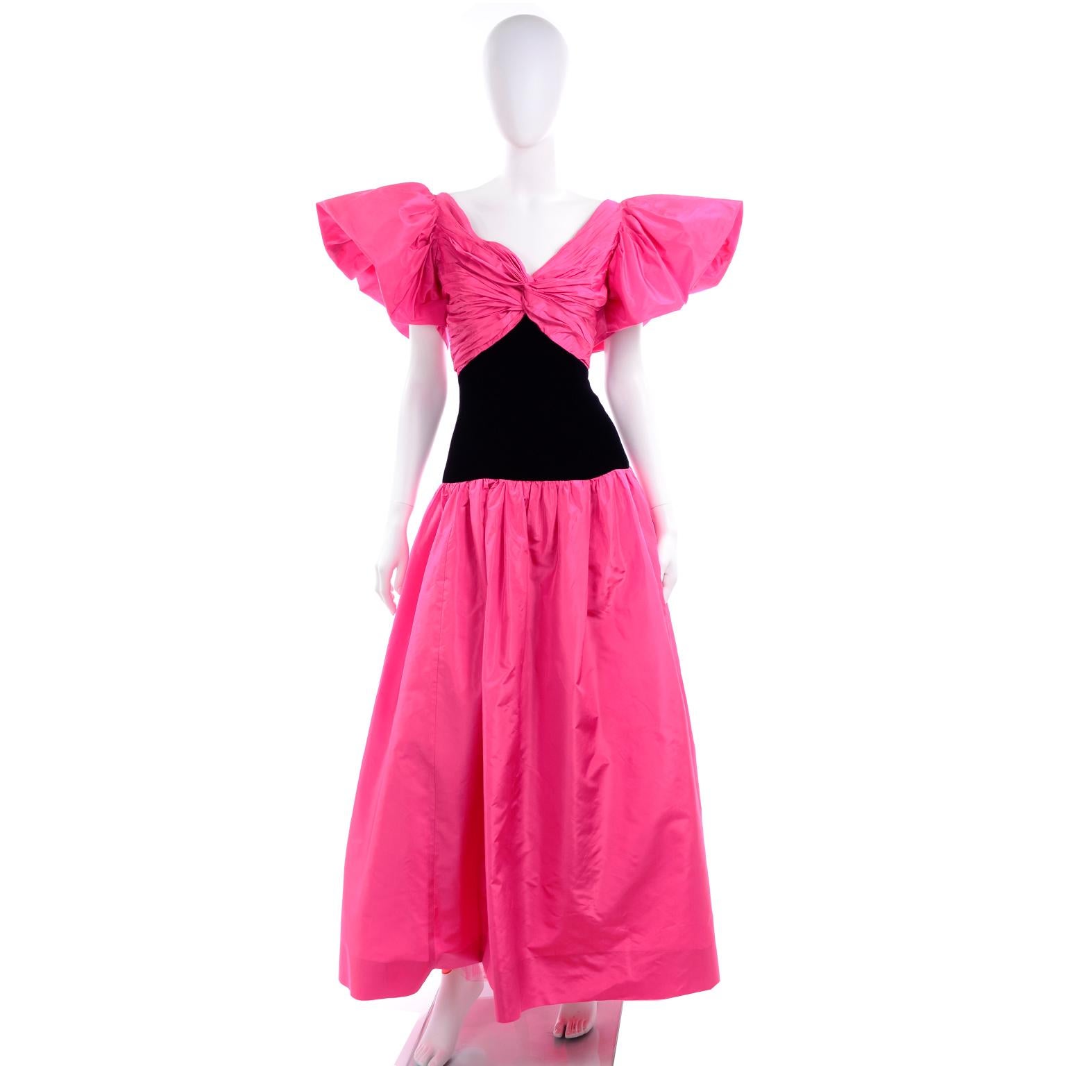 This is a gorgeous fuchsia pink taffeta long dress with black velvet at the waist Designed by Lorcan Mullany for Bellville Sassoon in the 1980's.  This lovely evening gown has dramatic slightly off shoulder butterfly sleeves and ruching at the bust.