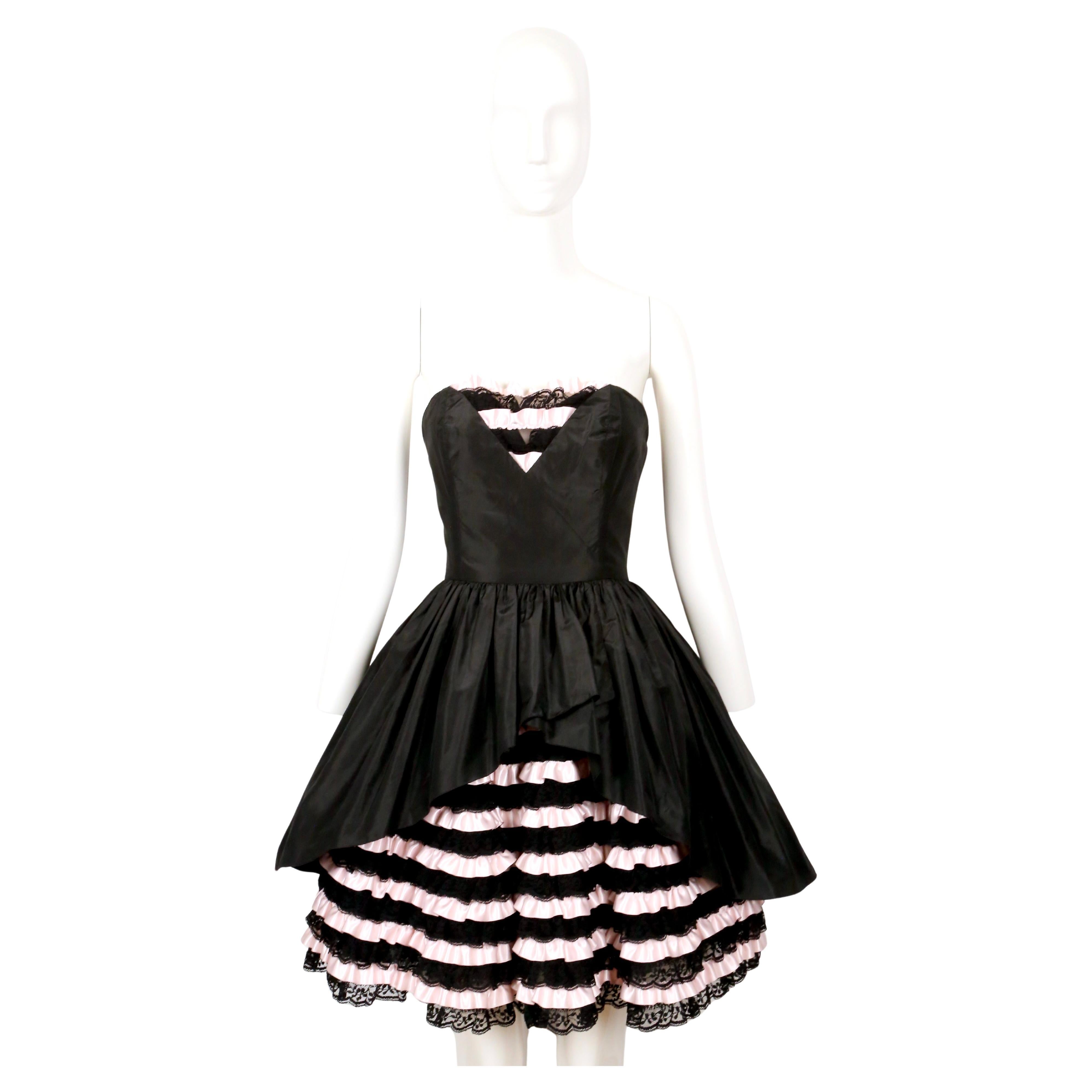 Dramatic jet-black and light pink mini dress with layered lace and ribbon ruffles designed by Loris Azzaro dating to the 1980's.  During this time, Azzaro was experimenting with volume and proportions and this is a perfect example of that work. This