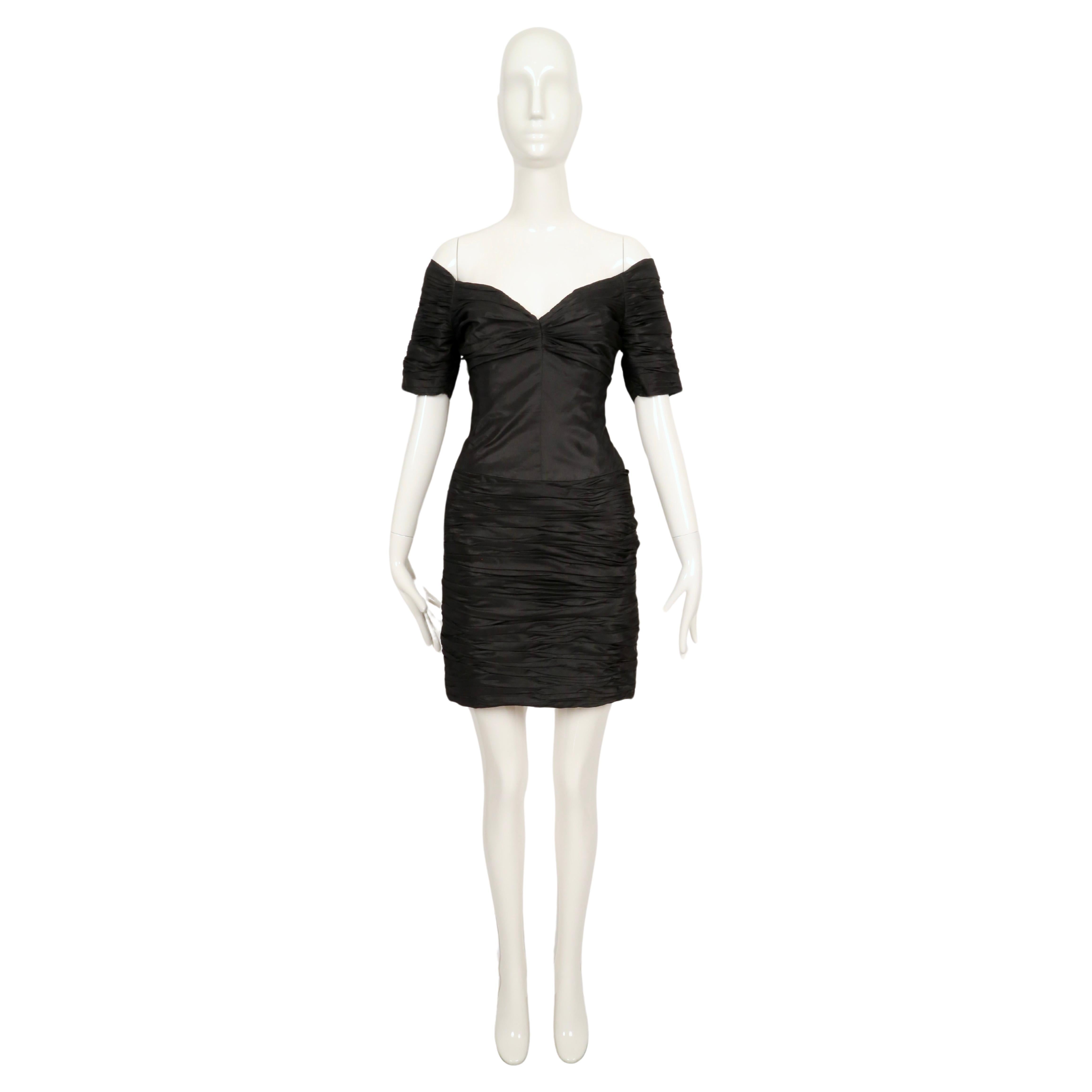 Vestido negro con pliegues diseñado por Loris Azzaro que data de principios de los años 80. El vestido se ajusta mejor a una talla 2-4 de EE.UU. Medidas aproximadas: busto 32-33