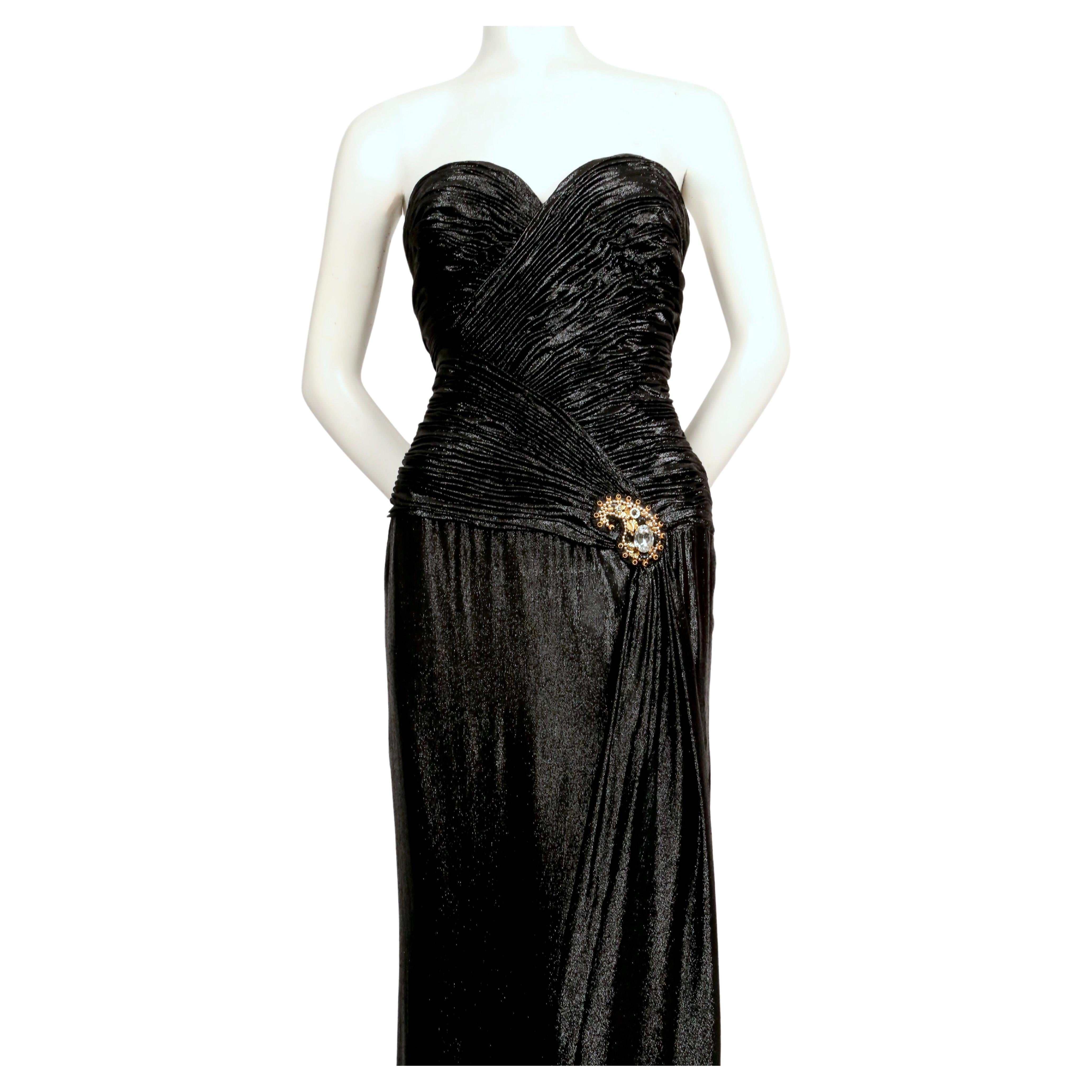 Metallic black dress with ruched bodice and beaded waist embellishment designed by Loris Azzaro dating to the early 1980's. No size indicated however this dress best fits a 4-6.  Measures approximately 34
