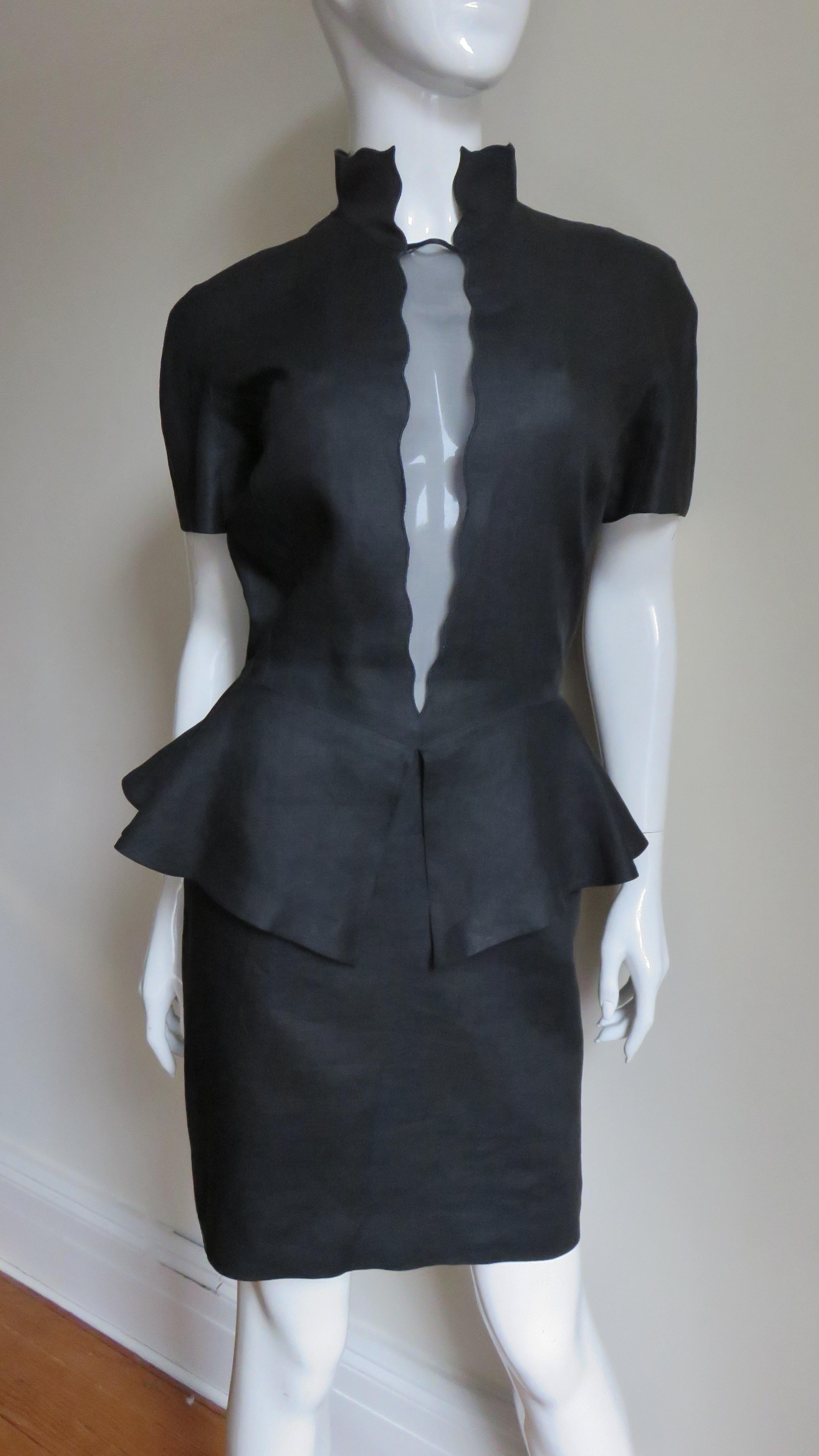 A great black fine linen dress from Louis Feraud.  It has a standup collar with a narrow plunging wedge of sheer black with subtle scallop edges from neck to waist. The short sleeves are cut in one piece with the bodice and have panels under the