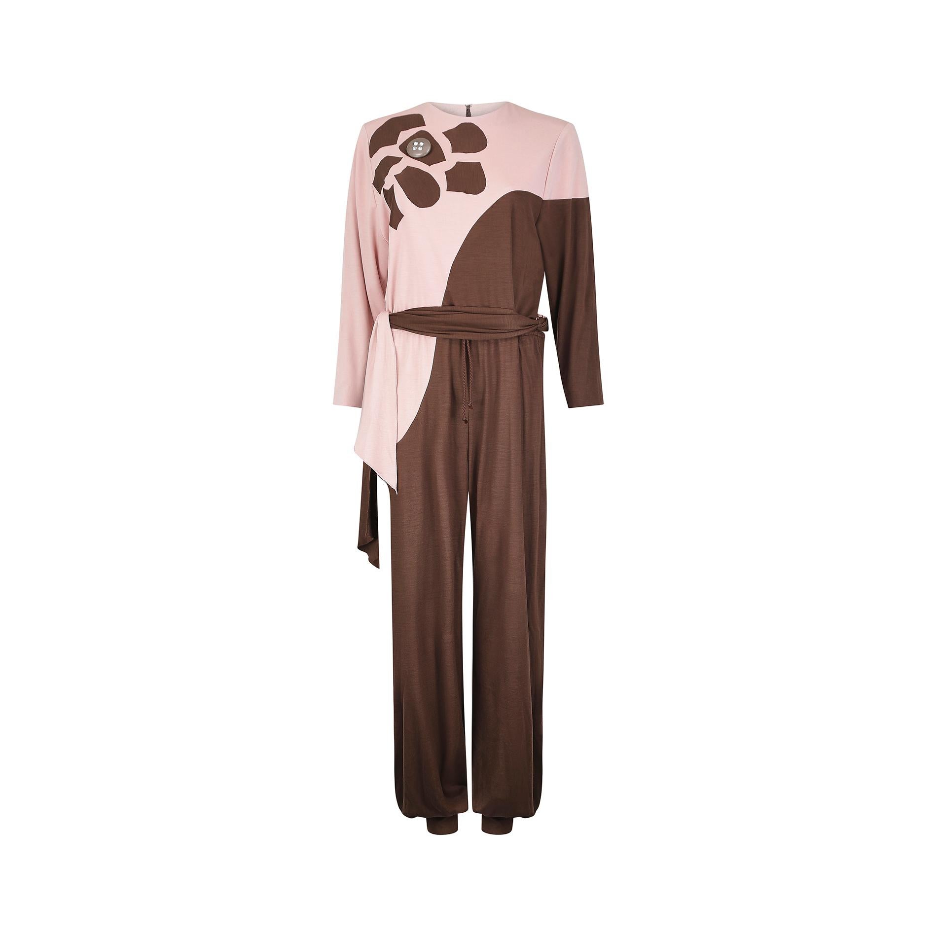 An early form of athleisure wear, this late 1970s to early 1980s Louis Mari jumpsuit is constructed from a soft and lightweight wool/acrylic jersey material in shades of pale pink and brown. It has a high, rounded neckline with sleeves which narrow