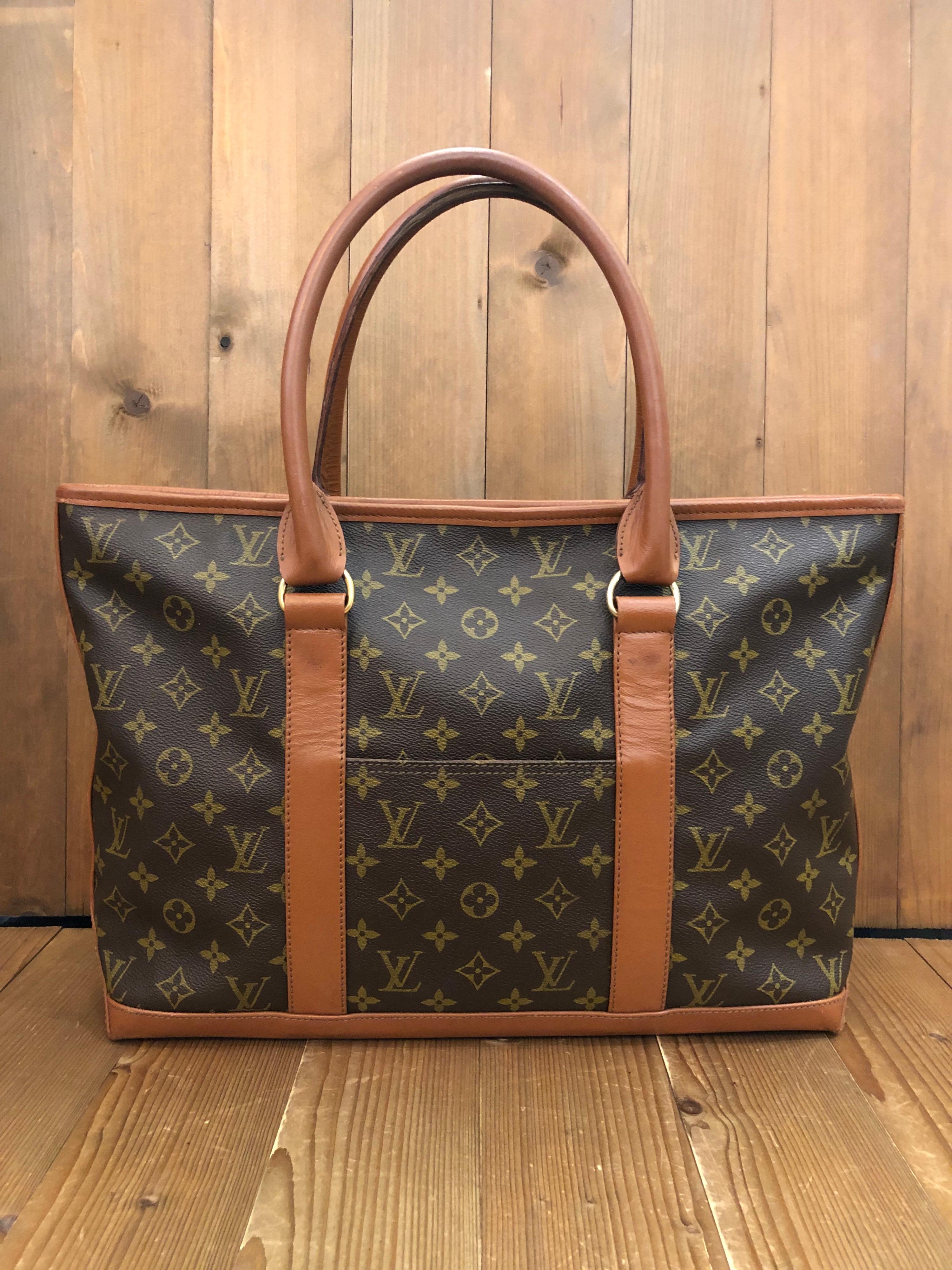 This tote bag by Louis Vuitton is perfect to carry all day long. it is crafted of monogram canvas and leather with gold-toned hardware. It features one open pocket each on the front and the back and one interior zip pocket. Made in France in
1983